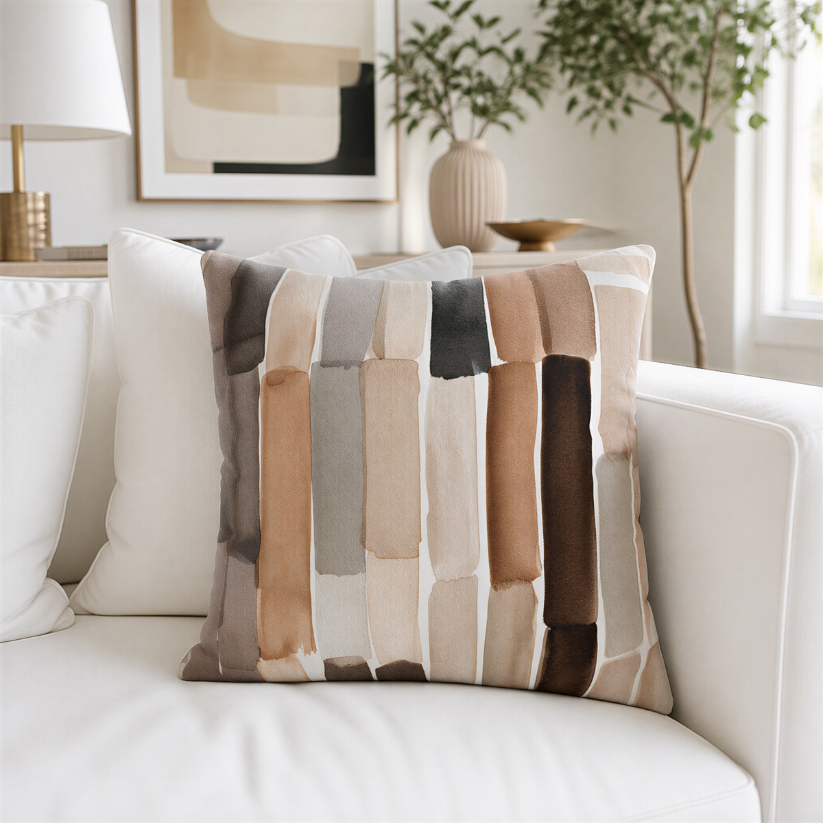 a living room with a white couch and a decorative throw pillow with a striped pattern in various shades of brown and beige.