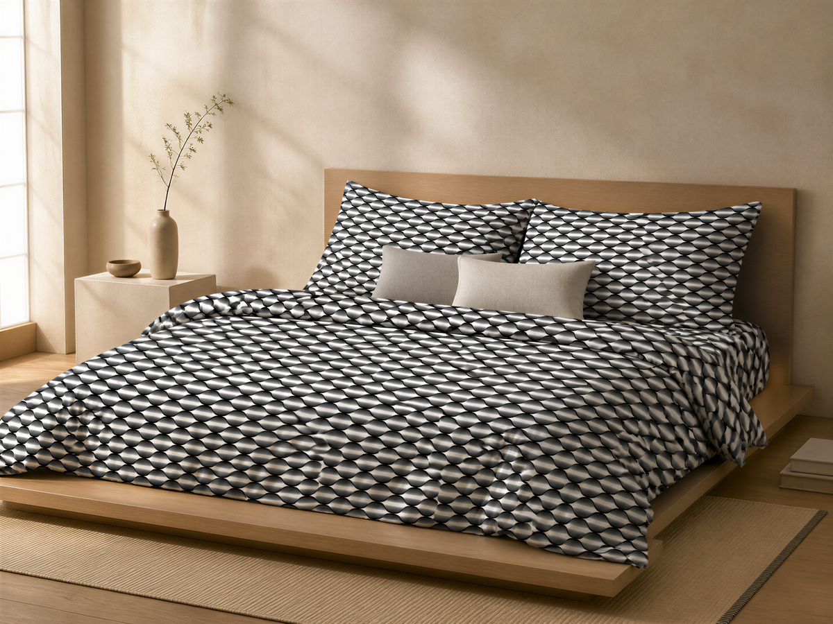 a modern bedroom with a bed featuring a black and white geometric comforter and matching pillows. The bed is placed on a wooden platform, and there is a small side table next to it. A vase with a plant is also present on the table. The room has a neutral color scheme, with a beige wall and a wooden floor.