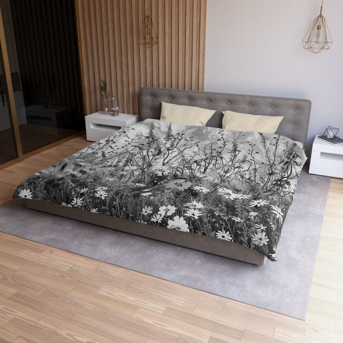 a modern bedroom with a large bed, a gray headboard, and a gray and white floral comforter. The room has a wooden floor and white walls, creating a serene and elegant atmosphere.