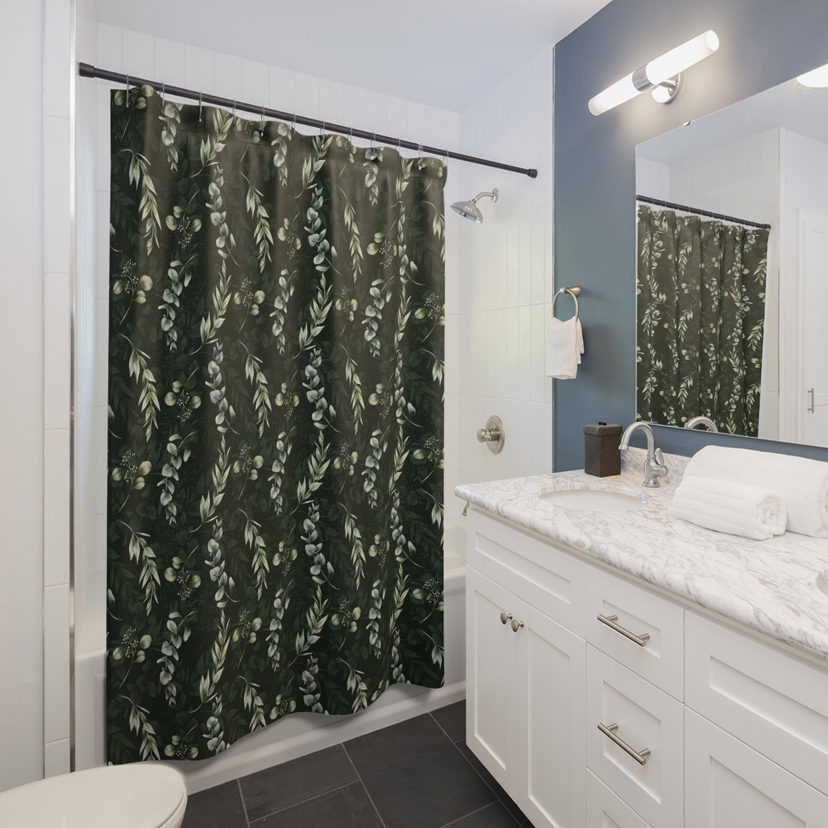 a modern bathroom with a white vanity, a green shower curtain with a leafy pattern, and a mirror above the vanity.