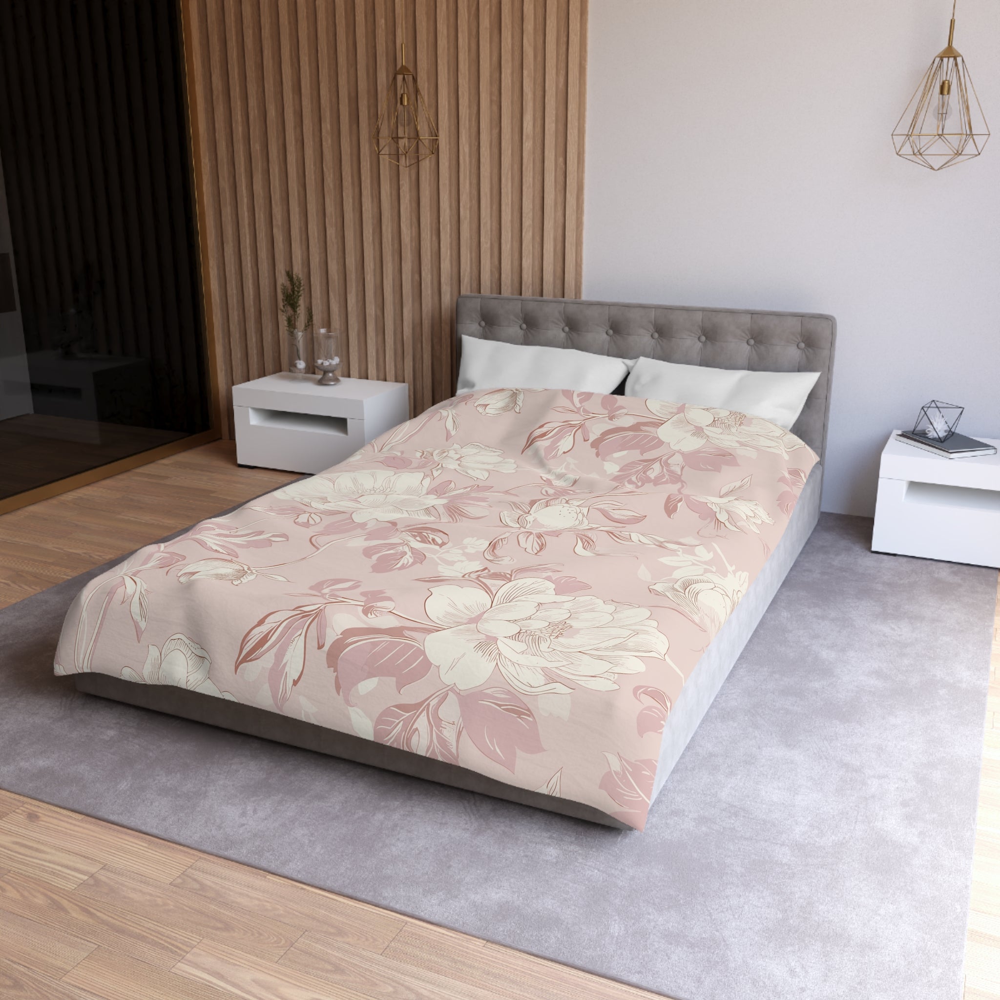 a modern bedroom with a large bed, a gray headboard, and a floral patterned comforter. The room has a neutral color scheme with a gray carpet and white walls. There are two nightstands on either side of the bed, and a pendant light hangs above the bed.