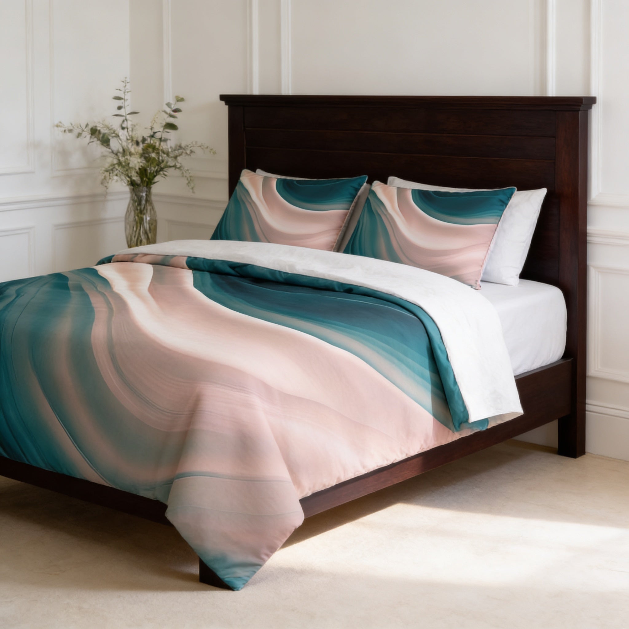a bedroom with a wooden bed frame and a colorful, abstract-patterned comforter and pillows. A vase of flowers is placed on the bedside table, and the room has white walls and a beige carpet.