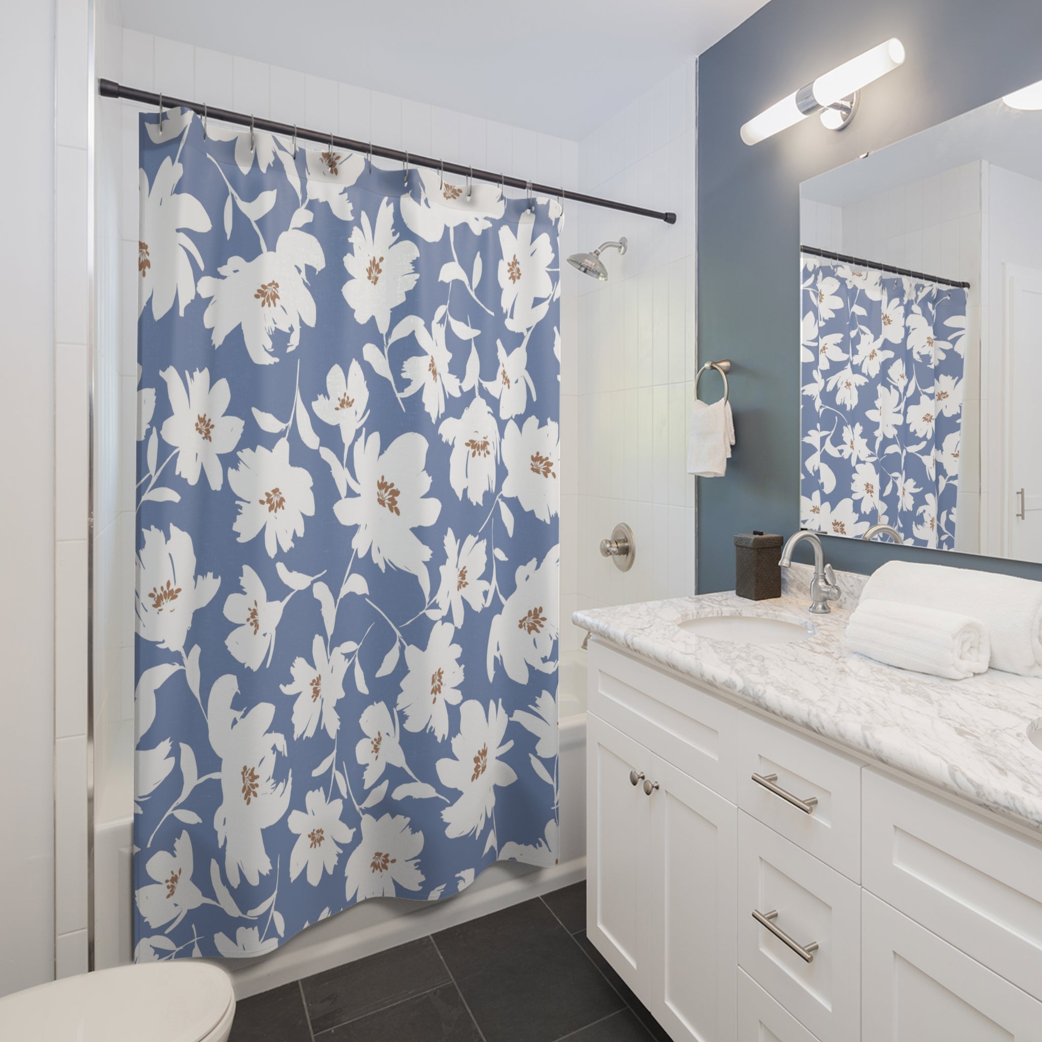 a modern bathroom with a white vanity, a blue floral shower curtain, and a white sink.