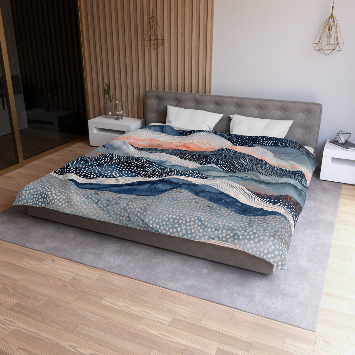 a modern bedroom with a large bed featuring a colorful, abstract patterned comforter. The bed is positioned against a wall with a wooden panel, and there are two nightstands on either side of the bed. The room has a minimalist and contemporary design, with a gray headboard and a wooden floor.