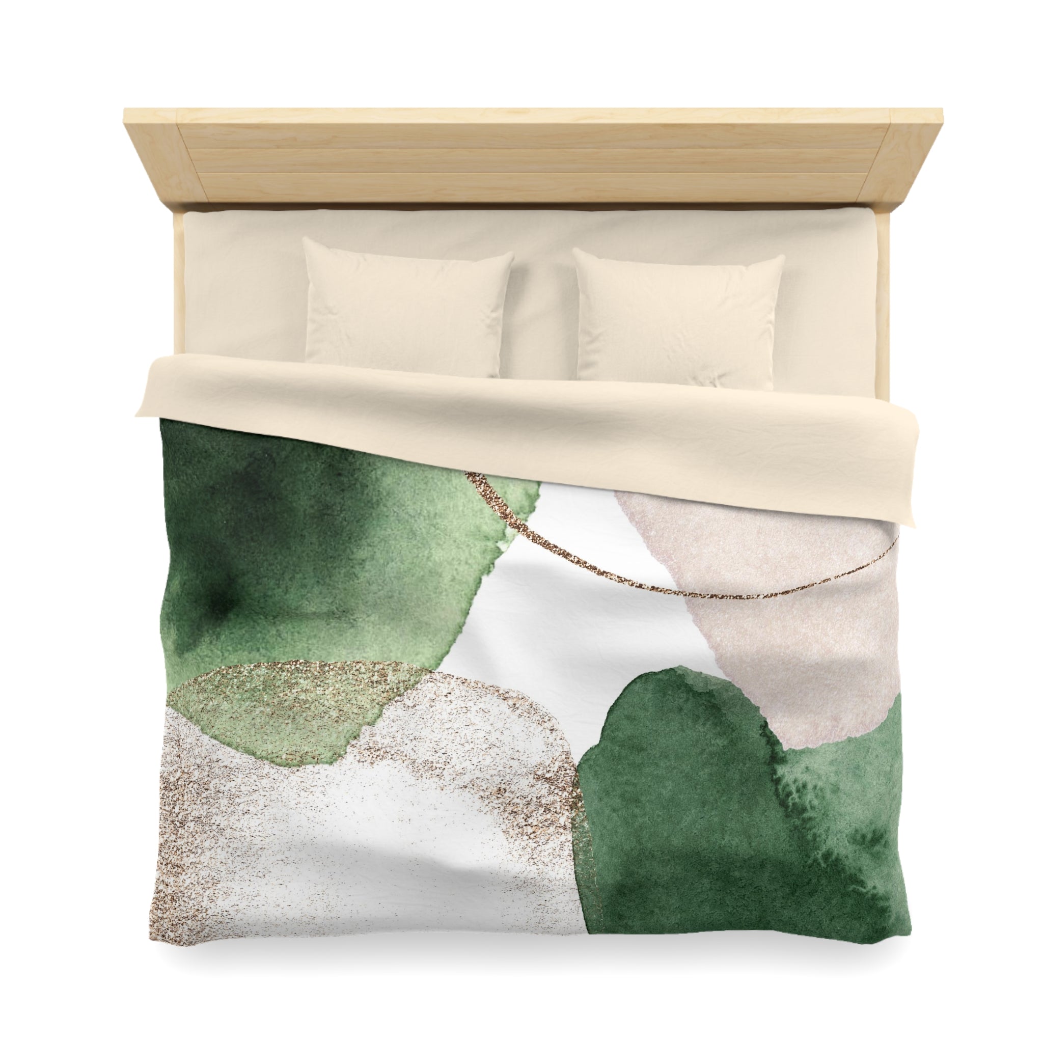 a bed with a green and white watercolor-style comforter and pillows.