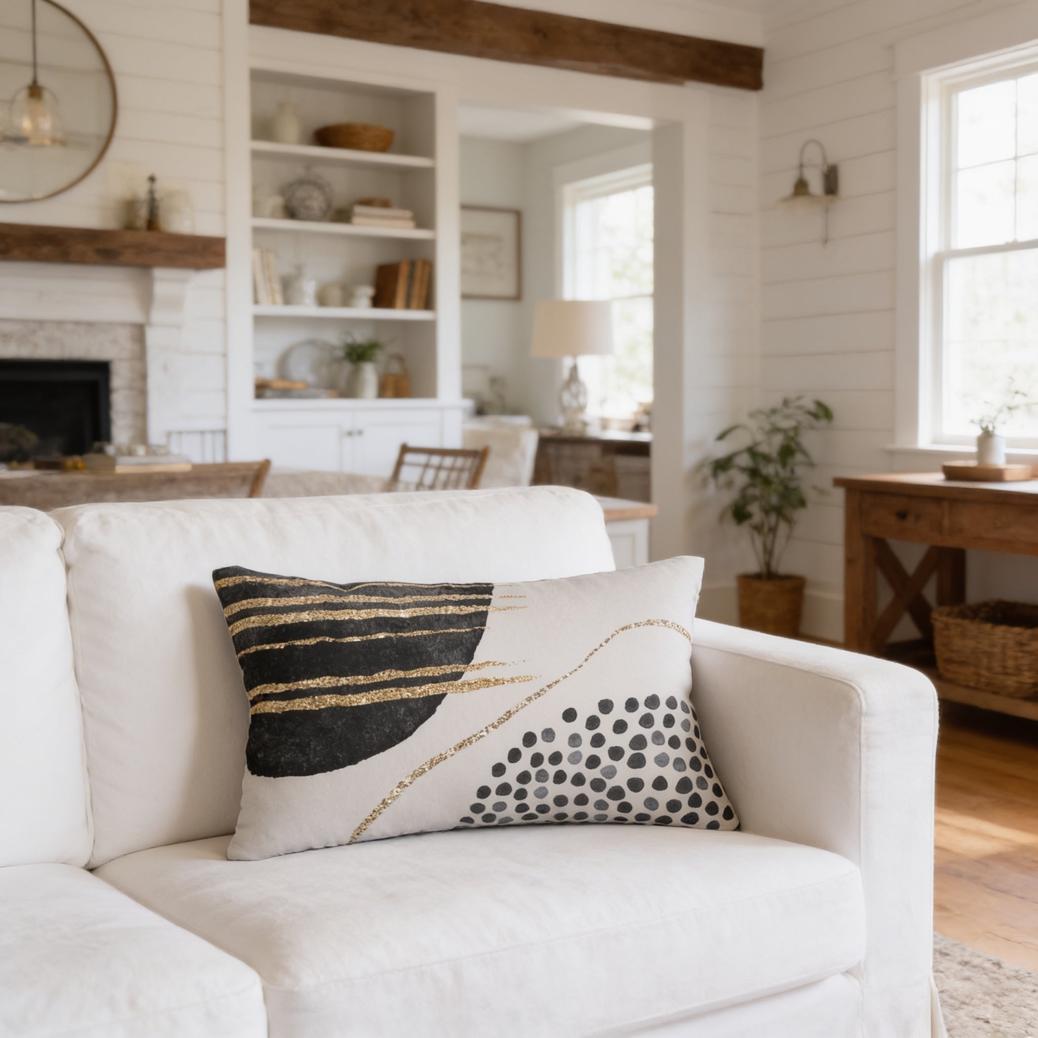 a cozy living room with a white sofa adorned with a decorative throw pillow. The room is well-decorated with various items such as books, vases, and potted plants, creating a warm and inviting atmosphere.