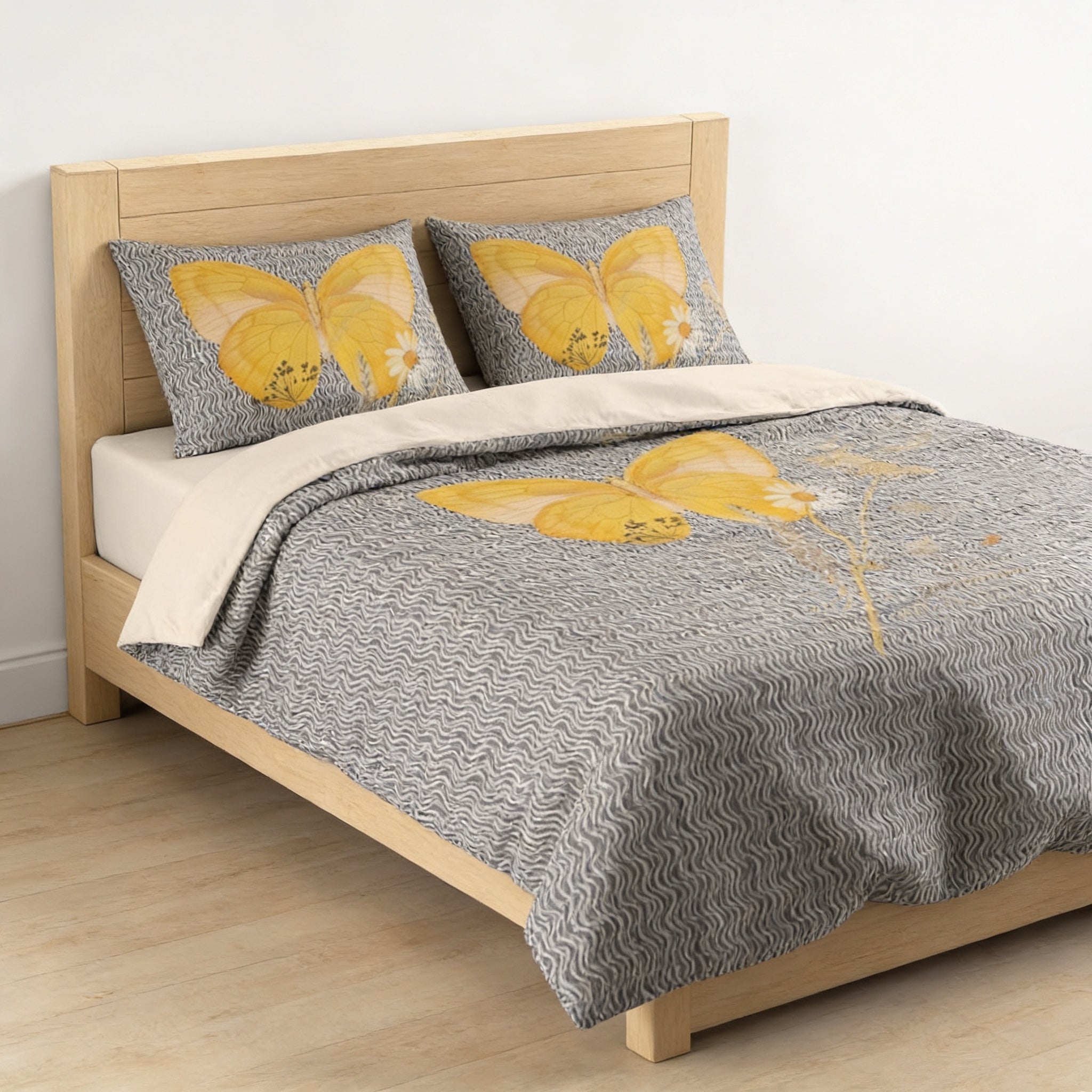 a bed with a gray and white patterned comforter and matching pillows featuring yellow butterfly designs.