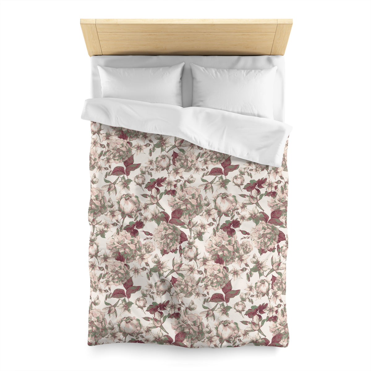 a neatly made bed with a floral print comforter and two white pillows.
