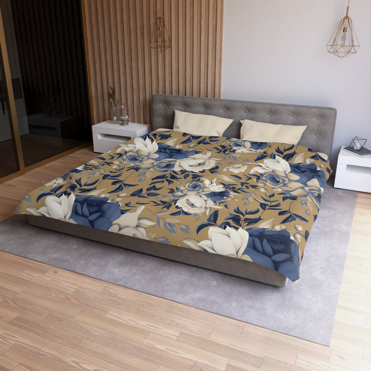 a bedroom with a large bed covered in a floral print comforter. The bed is positioned against a wall with a wooden panel. The room also features a nightstand, a pendant light, and a vase on a surface.