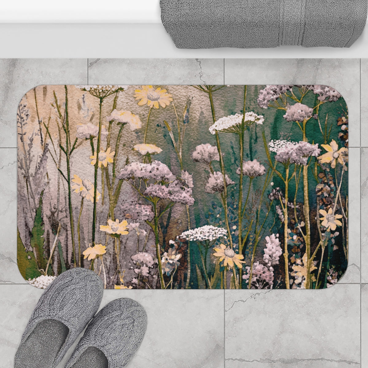 a bathroom rug with a floral design, including yellow and white flowers, along with green foliage. The rug is placed on a tiled floor, and there are gray slippers nearby.