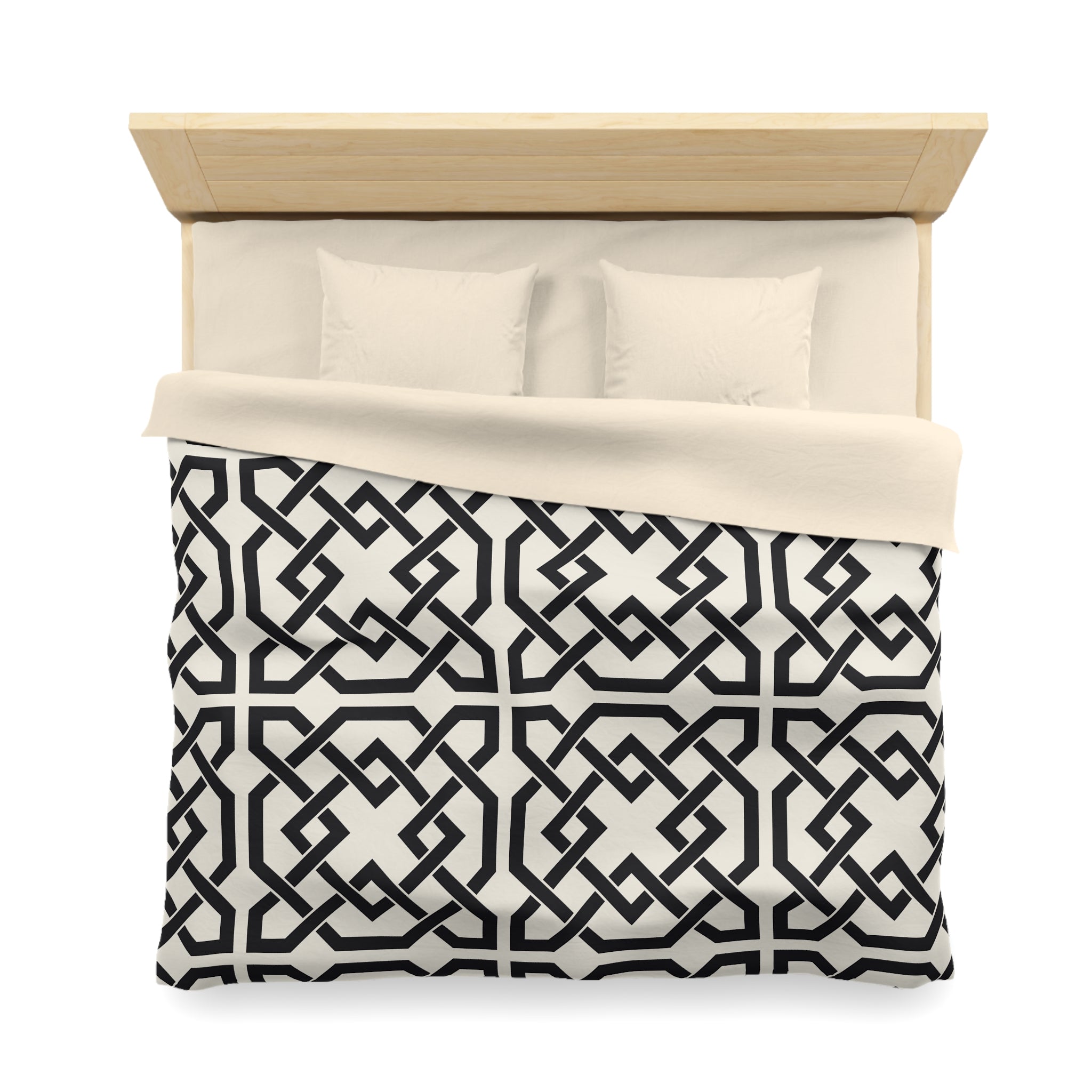 a neatly made bed with a black and white geometric patterned comforter and two pillows.
