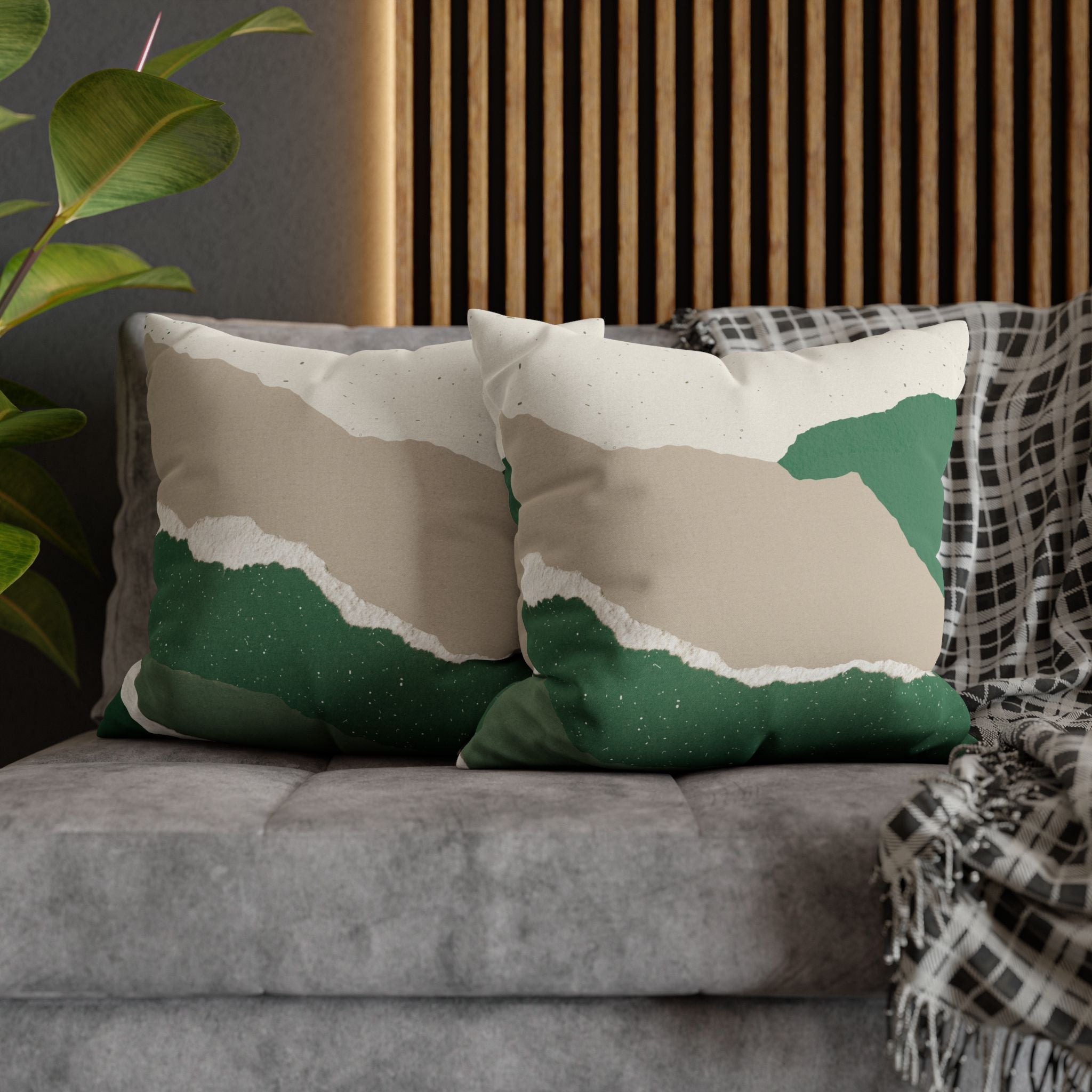 a gray couch with two green and white throw pillows on it.