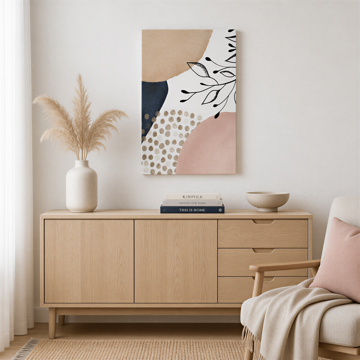 a modern and minimalist living room with a wooden cabinet, a white vase with dried flowers, a stack of books, and a beige armchair.