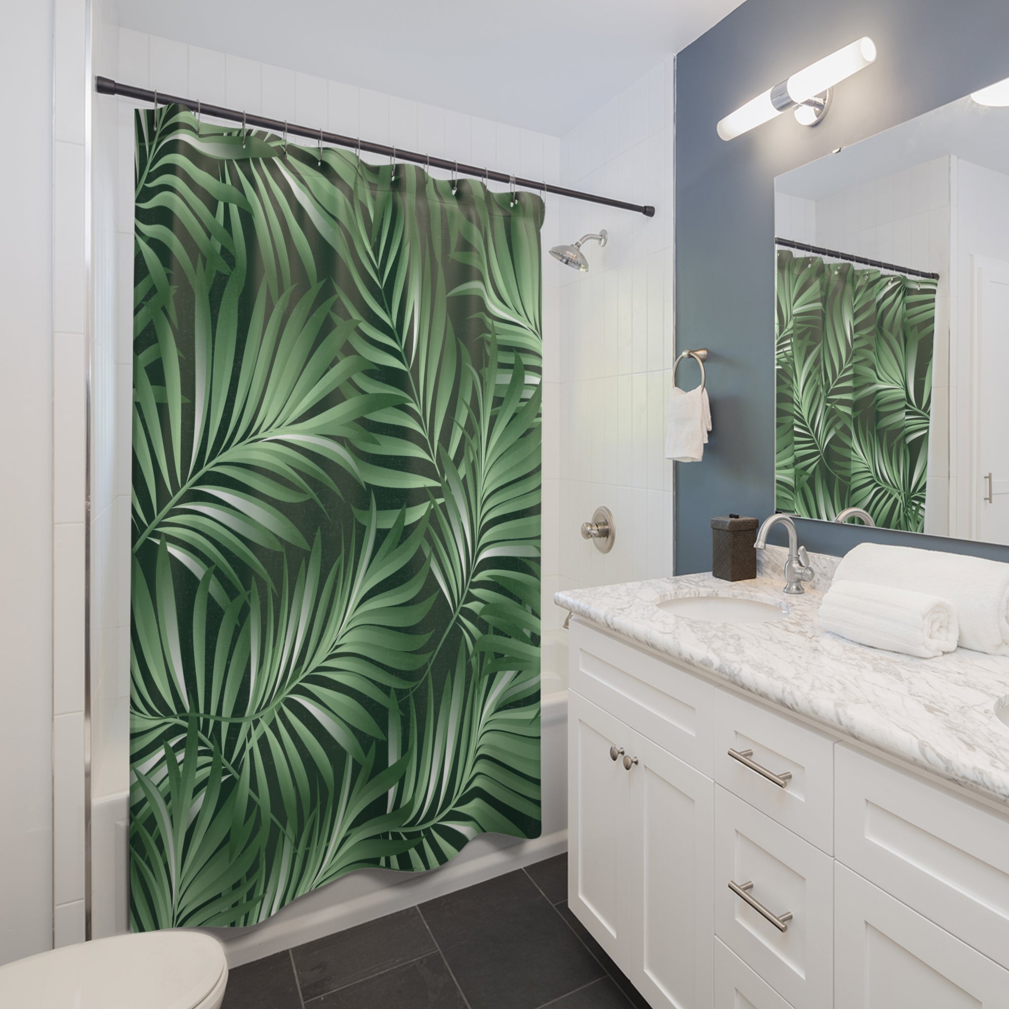 A modern bathroom with a white vanity, a large green leaf-patterned shower curtain, and a mirror above the sink.