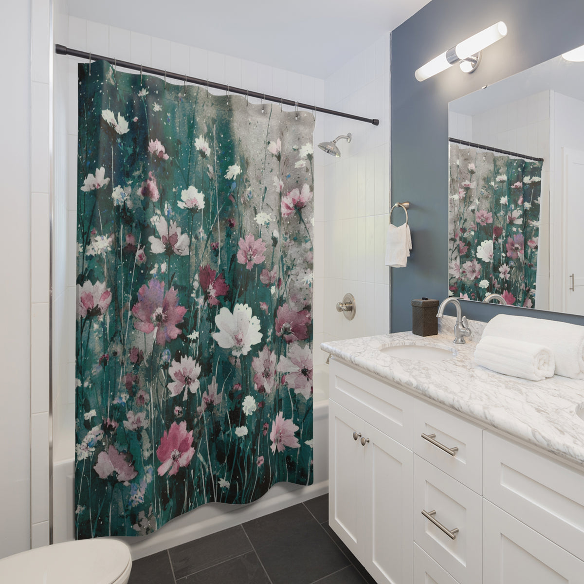 a bathroom with a shower curtain featuring a floral pattern in shades of green and pink. The bathroom has white cabinets, a marble countertop, and a large mirror.
