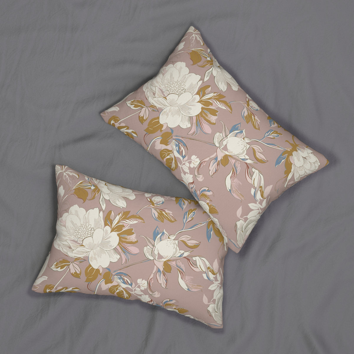 two decorative pillows with a floral pattern on a bed, featuring white and gold colors.