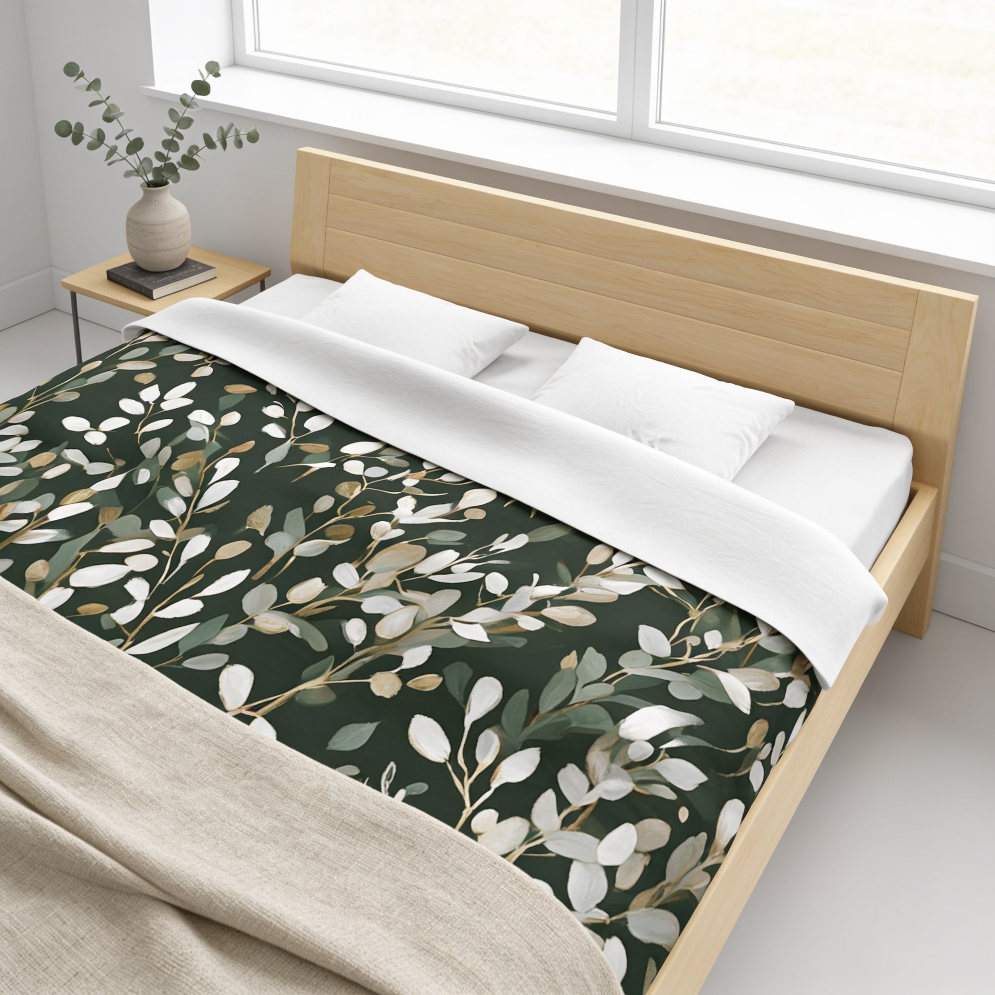 a modern bedroom with a wooden bed frame, a green and white leafy patterned bedspread, and a small side table with a plant.