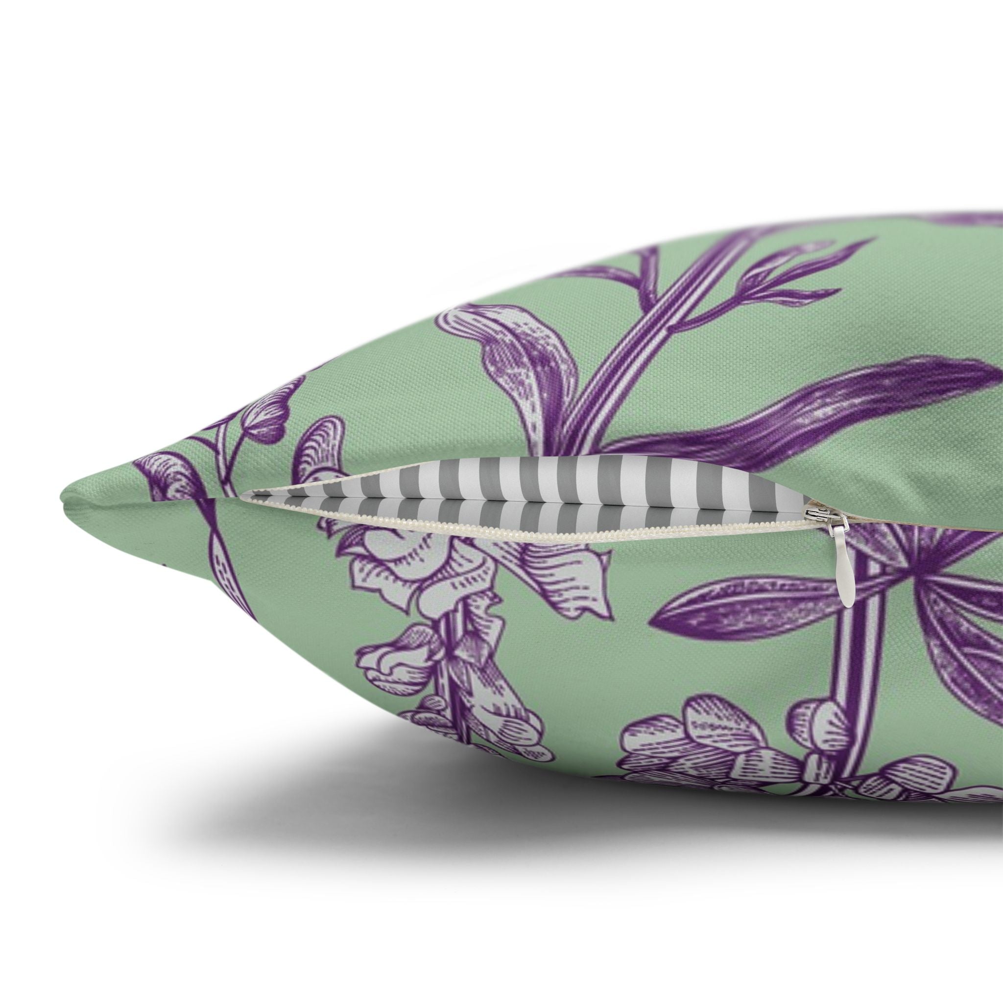 a close-up view of a green and purple floral patterned pillow with a striped interior.