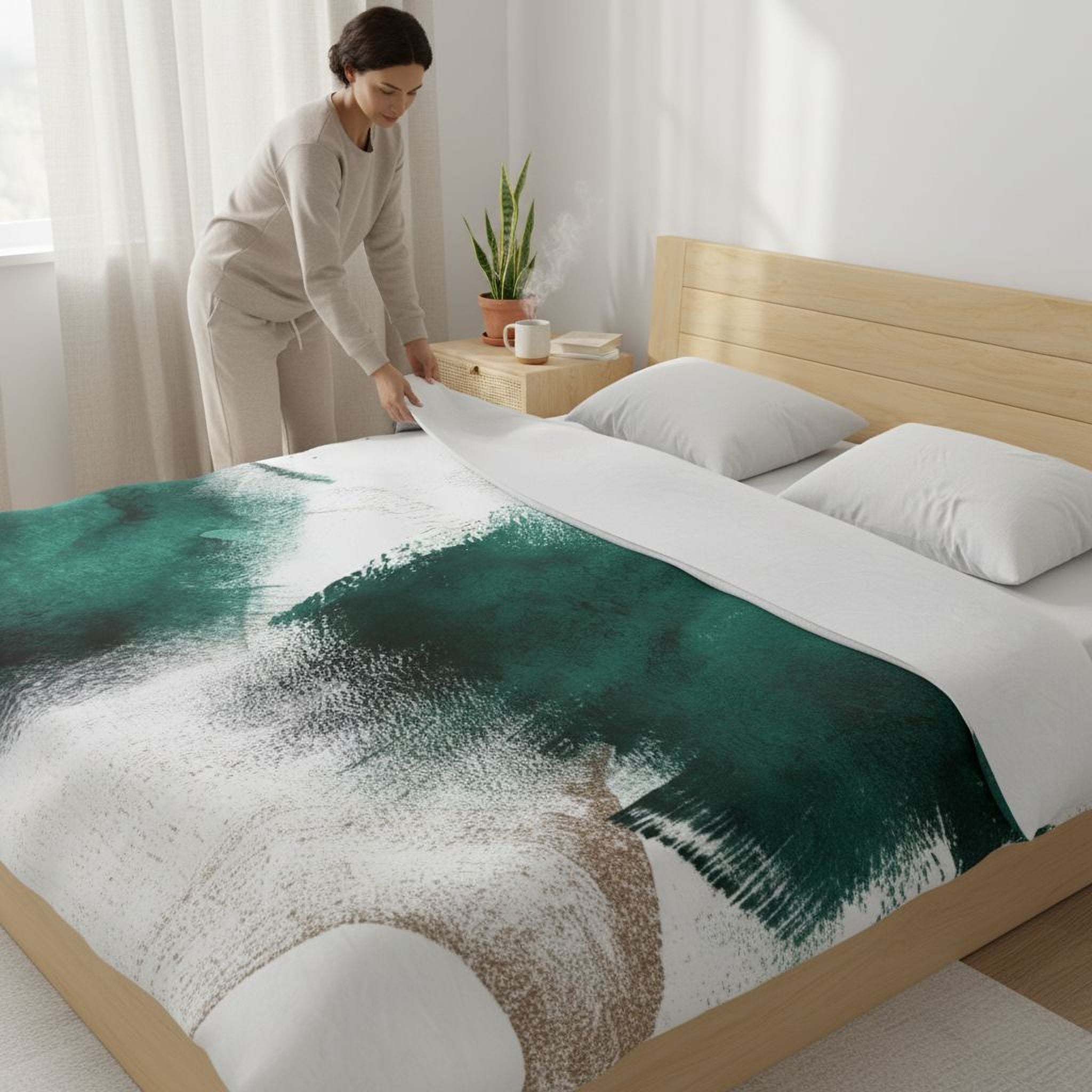 A woman is arranging a bed with a green and white patterned comforter and pillows.