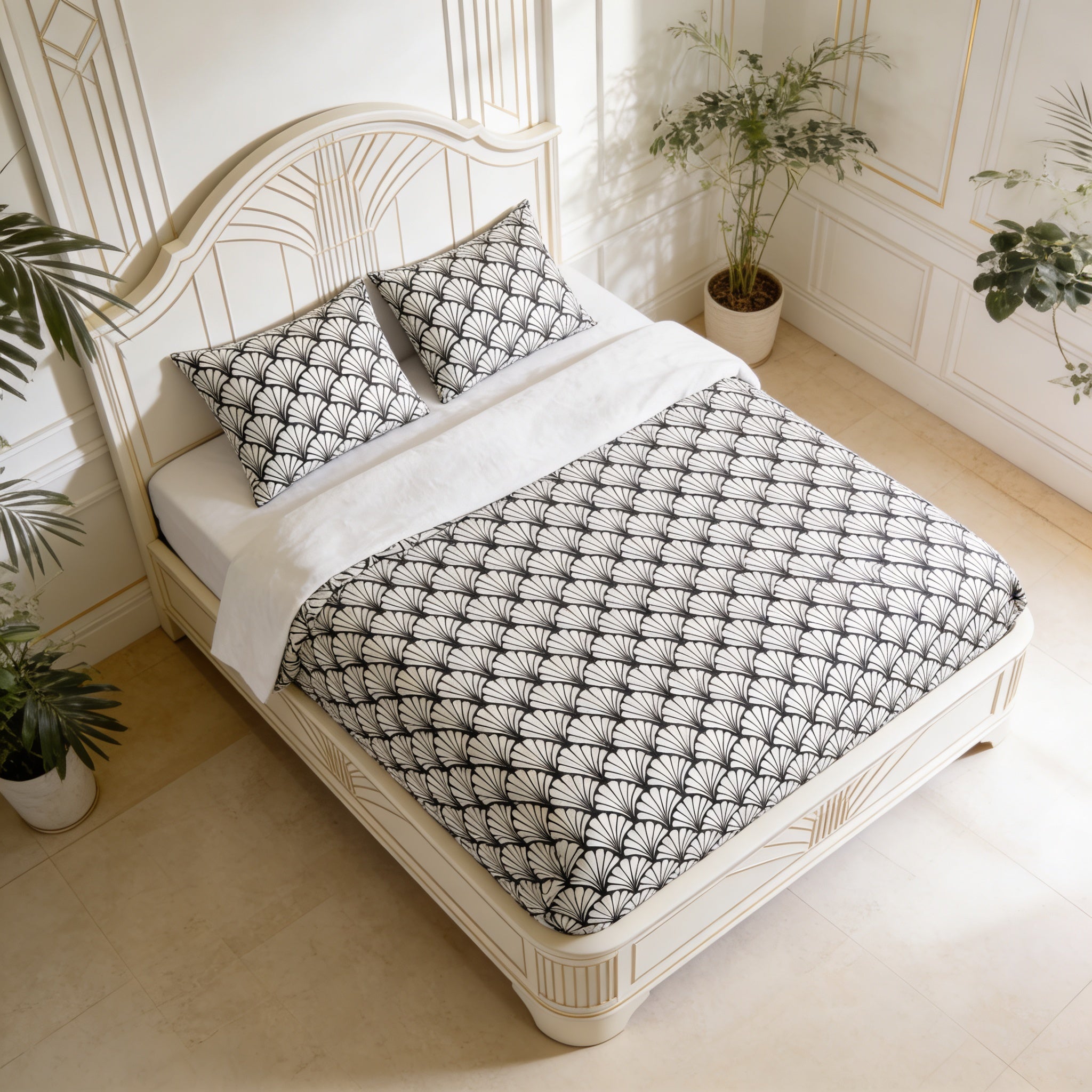 a bedroom with a white bed frame and a black and white patterned comforter. The bed is neatly made with a white sheet and two matching pillows. The room has a clean, minimalist aesthetic with white walls and a tiled floor. There are two potted plants in the room, one on the left side and the other on the right side, adding a touch of greenery to the space.