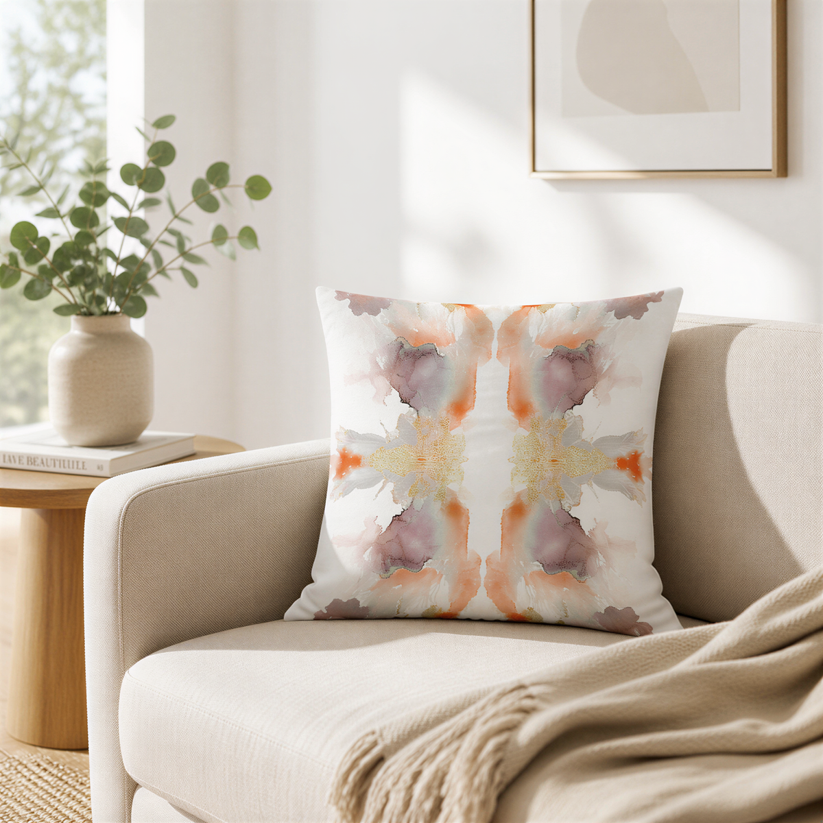 a cozy living room with a beige sofa, a white pillow with a colorful abstract pattern, and a wooden side table with a vase of greenery.