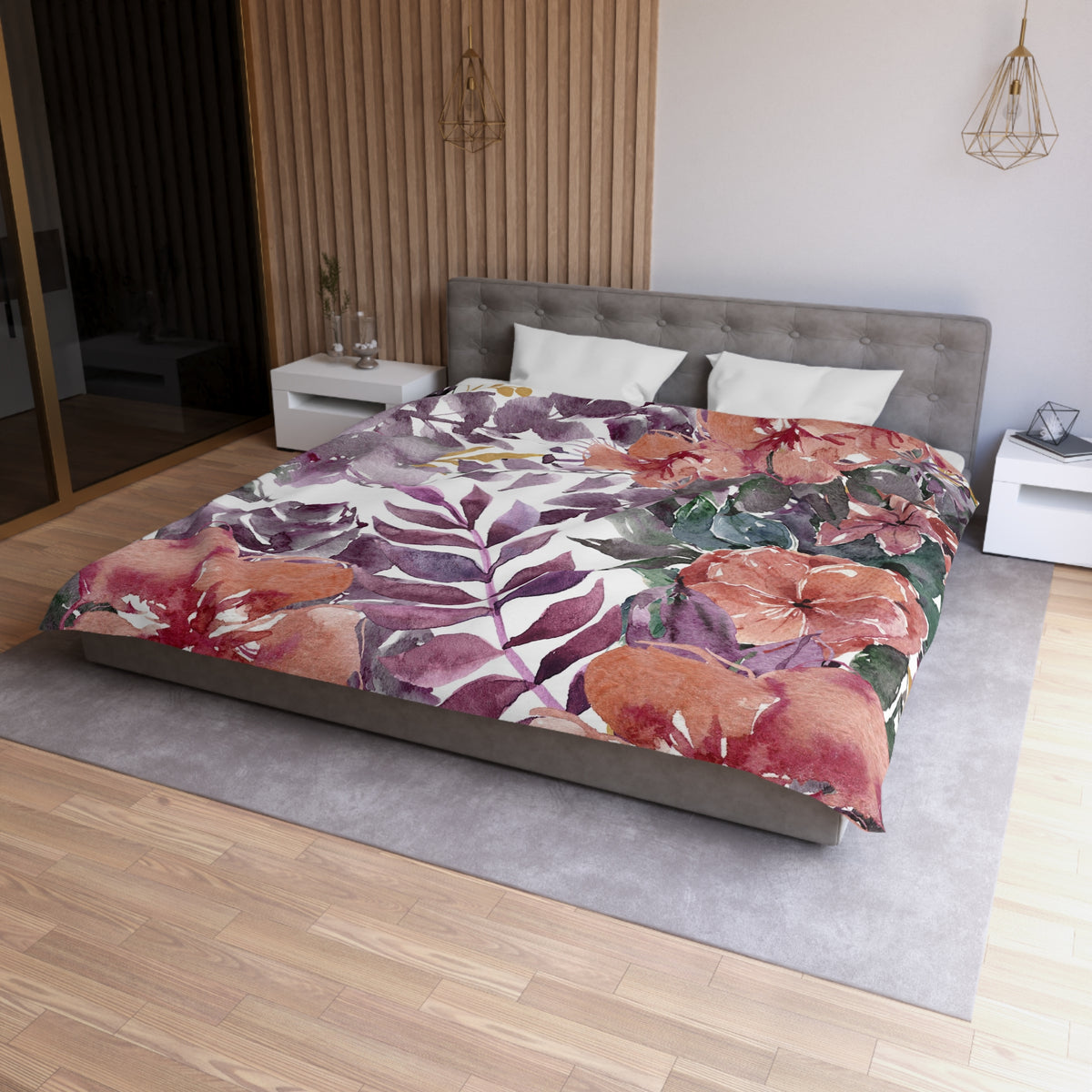 a modern bedroom with a large bed covered in a colorful floral print. The bed is positioned against a wall with a wooden panel, and there are two nightstands on either side of the bed. The room has a wooden floor and a gray rug, creating a cozy and inviting atmosphere.