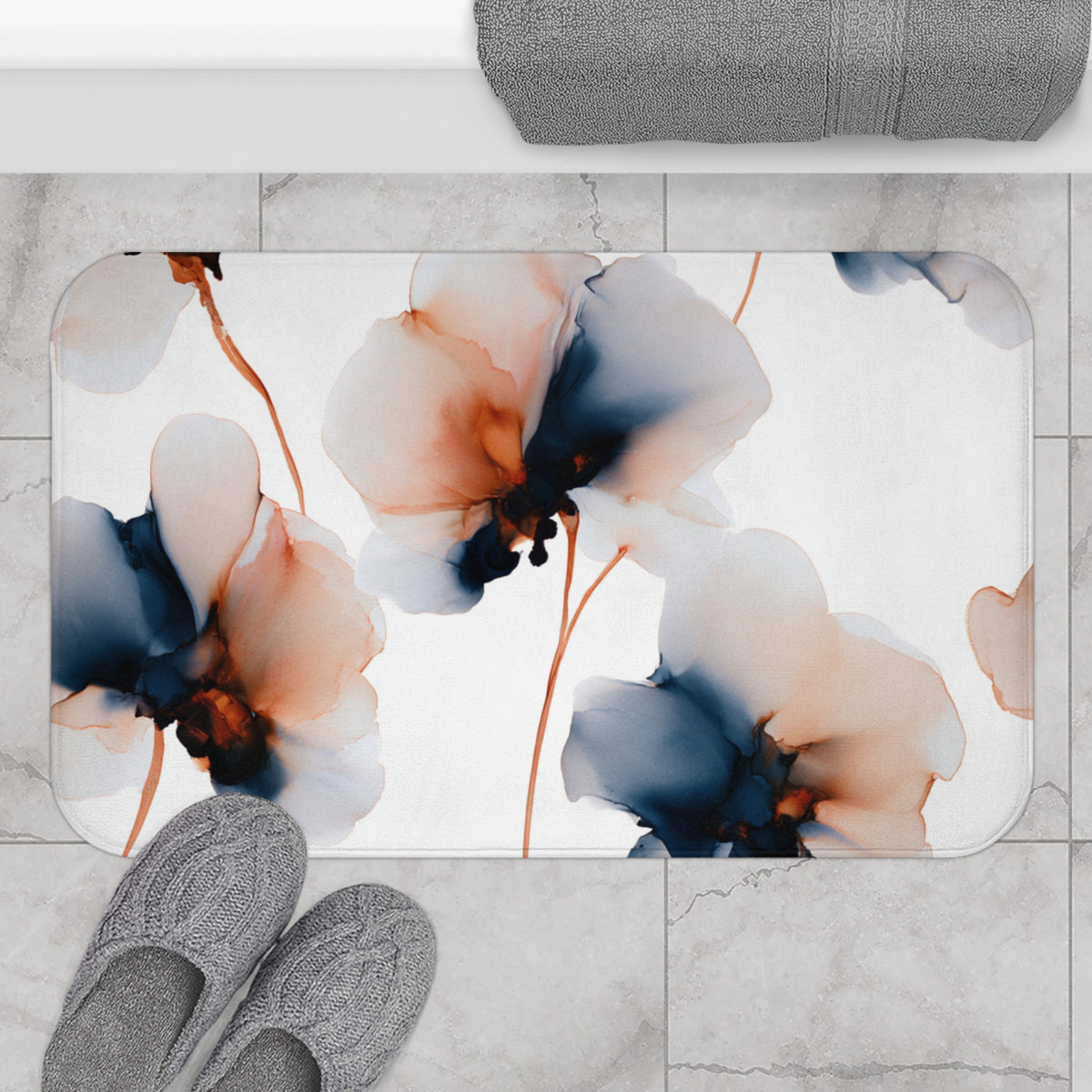 a bathroom mat with a floral design, placed on a tiled floor. There are two pairs of shoes visible in the image, one on the left side and the other on the right side.