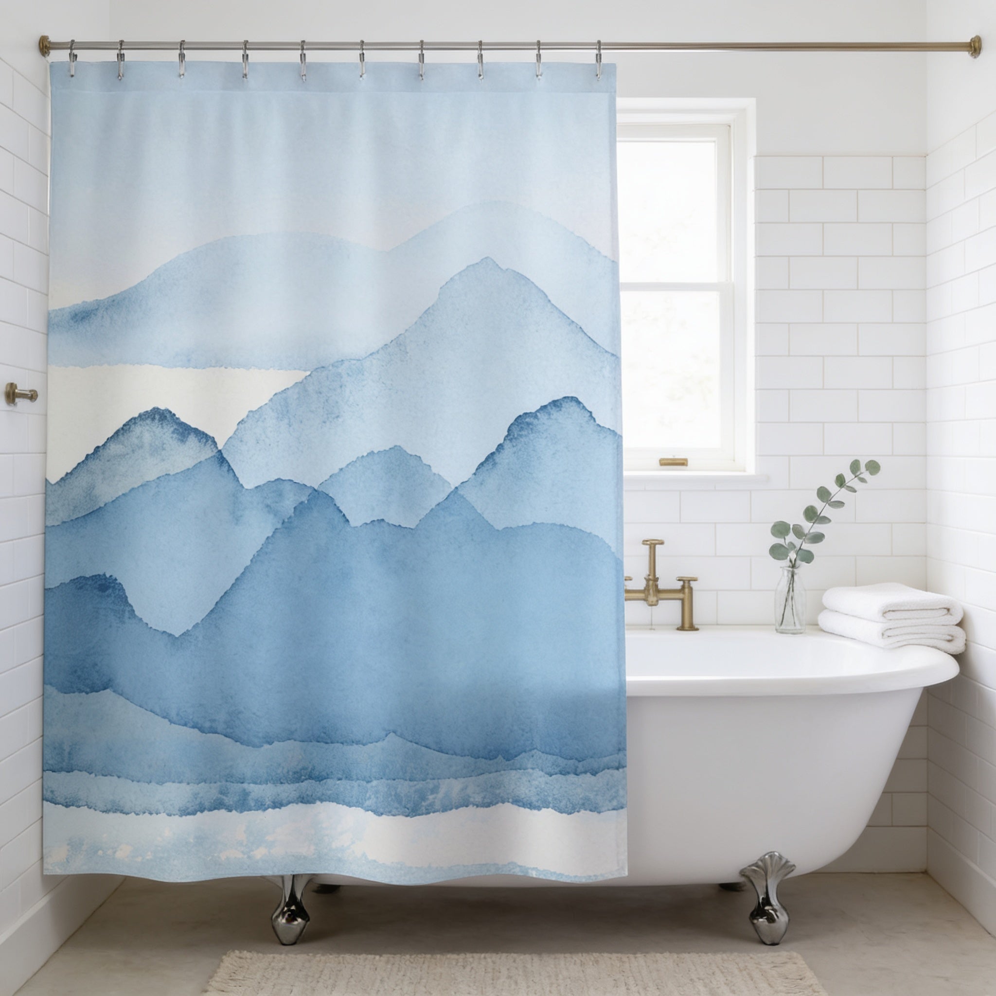 a bathroom with a white clawfoot bathtub, a shower curtain with a mountain landscape design, and a window above the bathtub.