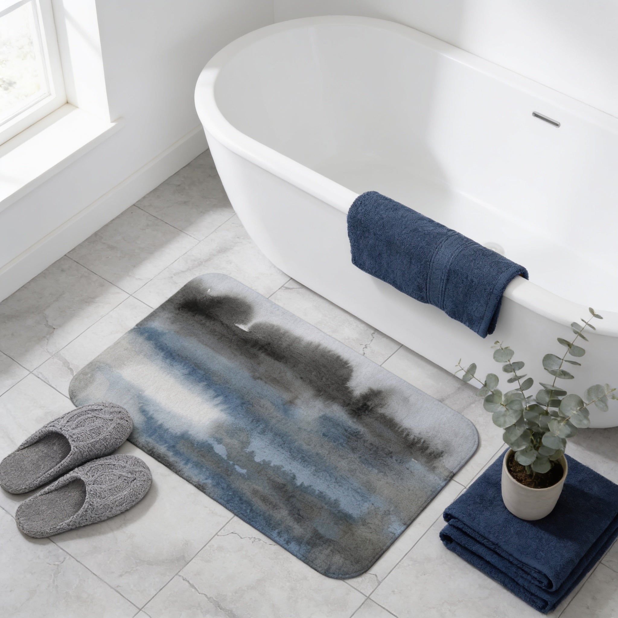 a bathroom with a white bathtub, a blue towel, a gray bath mat, a pair of gray slippers, and a potted plant.