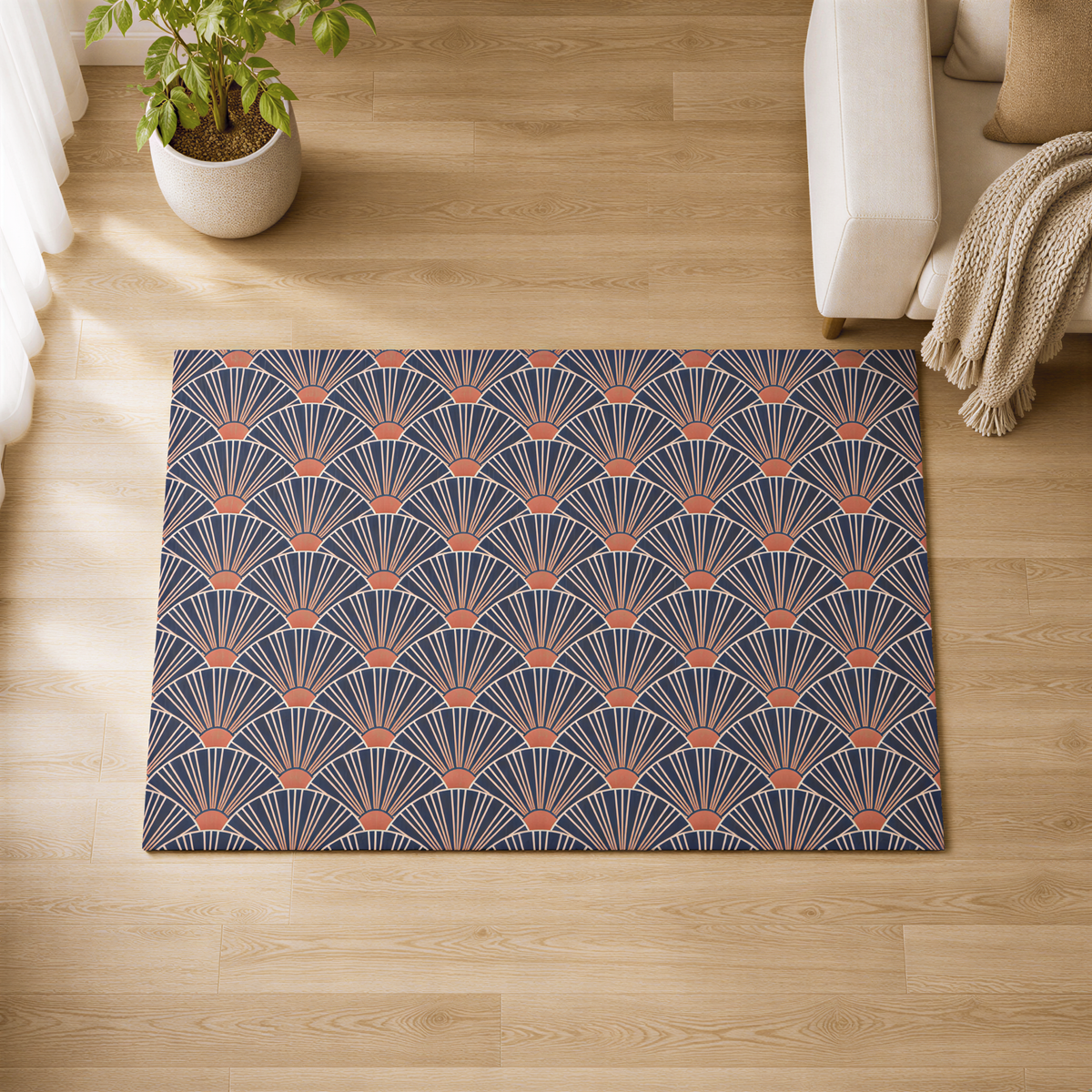 a living room with a large rug on the wooden floor, which has a repeating pattern of orange and blue waves or shells. The rug is placed next to a white couch, and there is a potted plant nearby.