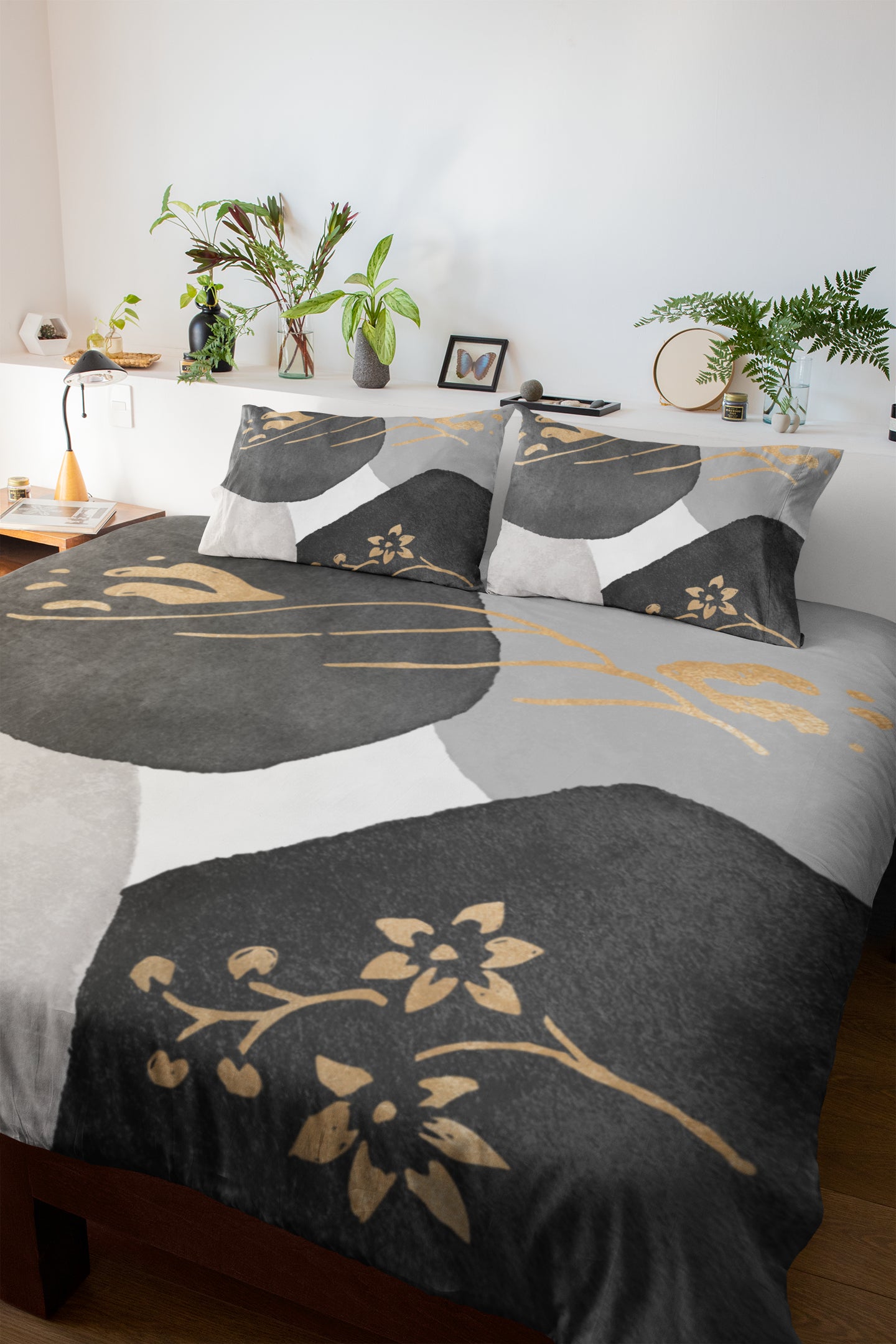 a bed with a black and gold comforter and pillows