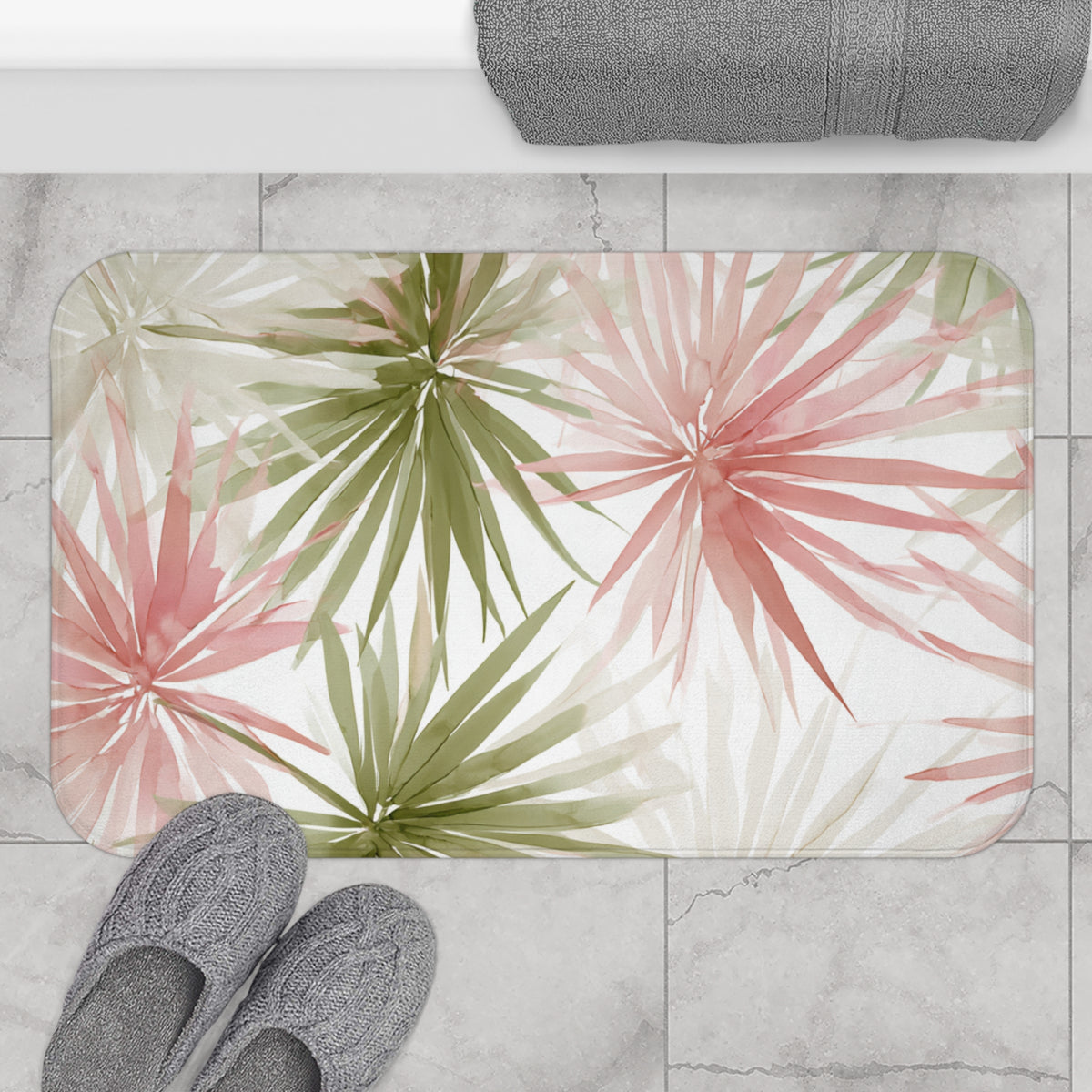 a bathroom mat with a tropical plant design, placed on a tiled floor. There are two pairs of shoes, one on the left side and one on the right side of the mat.
