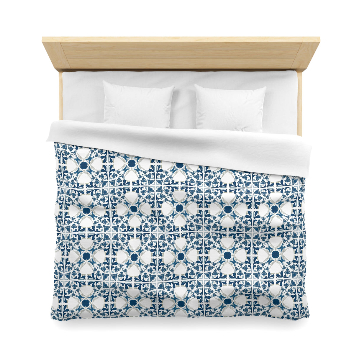 a neatly made bed with a blue and white patterned comforter and two white pillows.