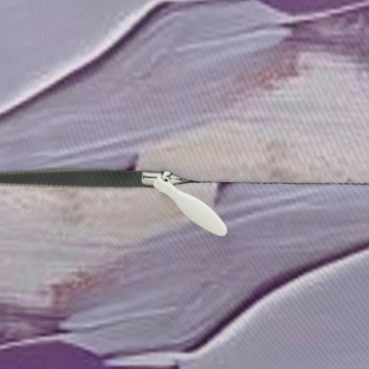 A close-up view of a zipper on a fabric, with a white plastic zipper pull visible.