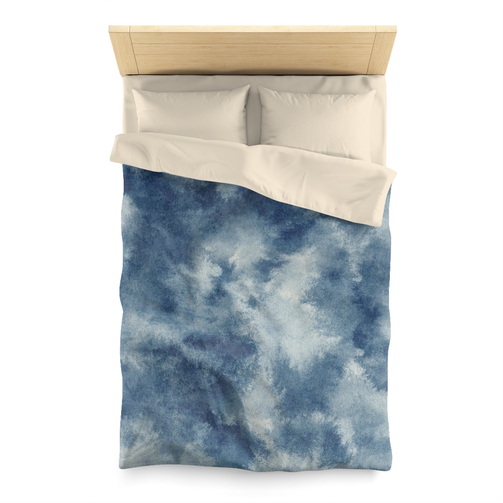 a neatly made bed with a blue and white patterned comforter and two pillows.