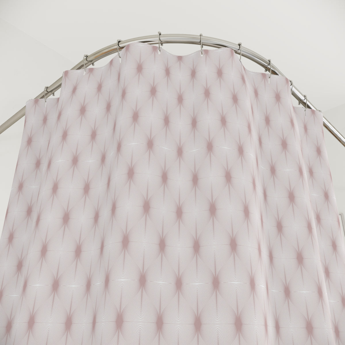 a curved metal rod with a pink and white patterned shower curtain hanging from it.