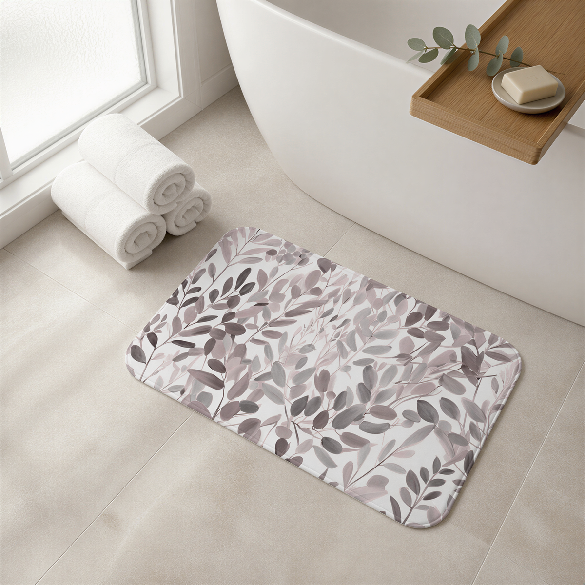 a bathroom with a white bathtub, a decorative bath mat with a leaf pattern, and rolled towels on the floor.