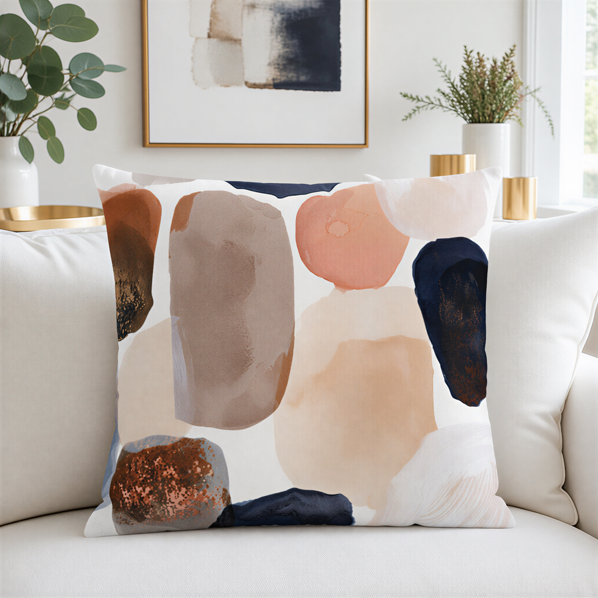 a white couch with a decorative throw pillow featuring a colorful abstract design in shades of brown, orange, and beige. The pillow is placed on the couch, creating a visually appealing and cozy atmosphere in the room.