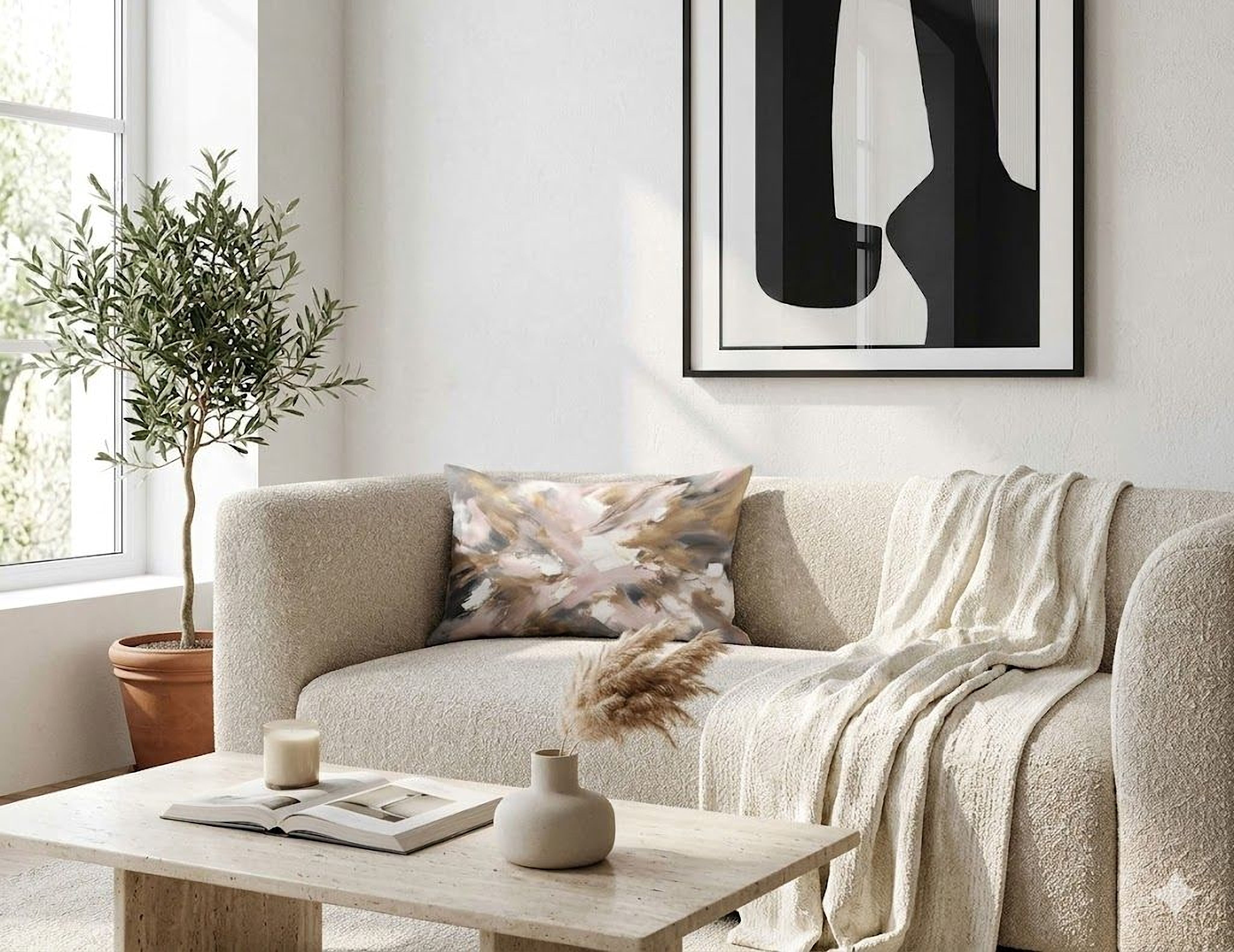 a cozy living room with a beige sofa, a wooden coffee table, and a large abstract painting on the wall. The room is decorated with a potted plant, a vase with dried flowers, and a book on the coffee table.