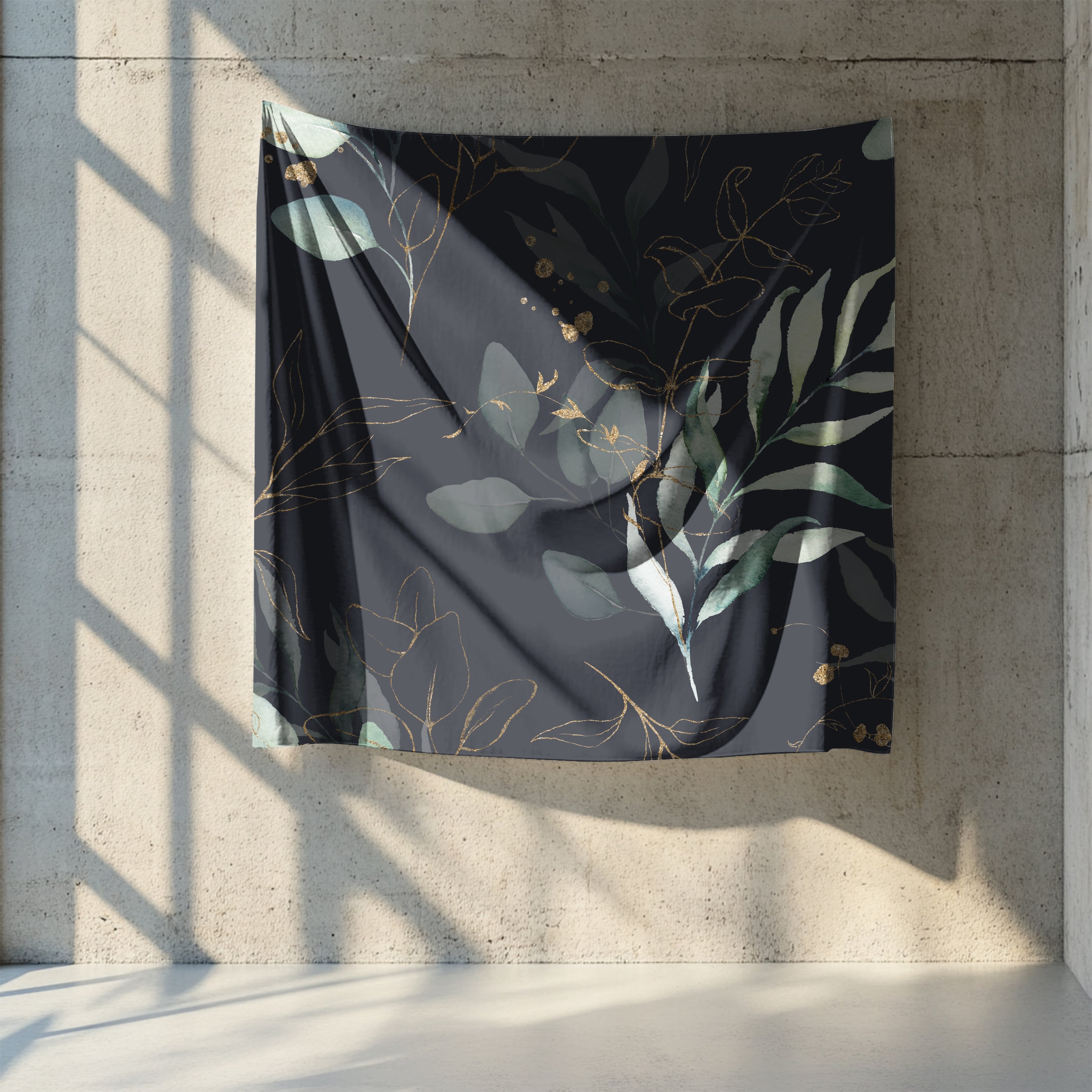 a large black fabric with a gold leaf pattern hanging on a concrete wall.