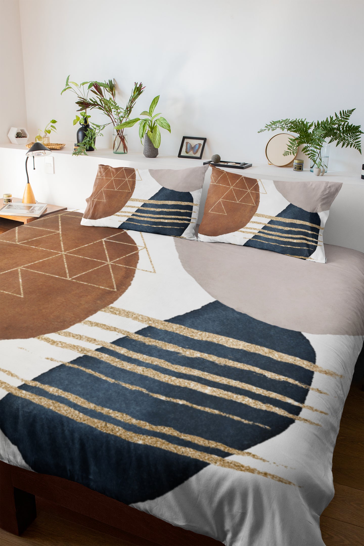 a bed with a blue and gold comforter and pillows