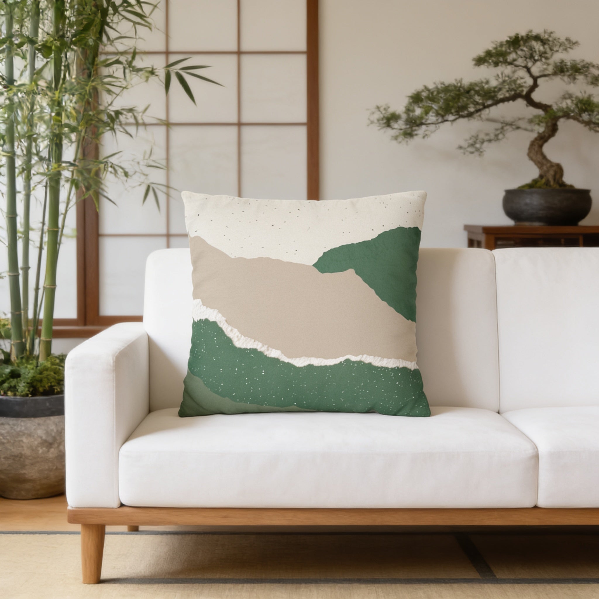 a white couch with a green and beige throw pillow on it, placed in a room with a large window and a potted plant.