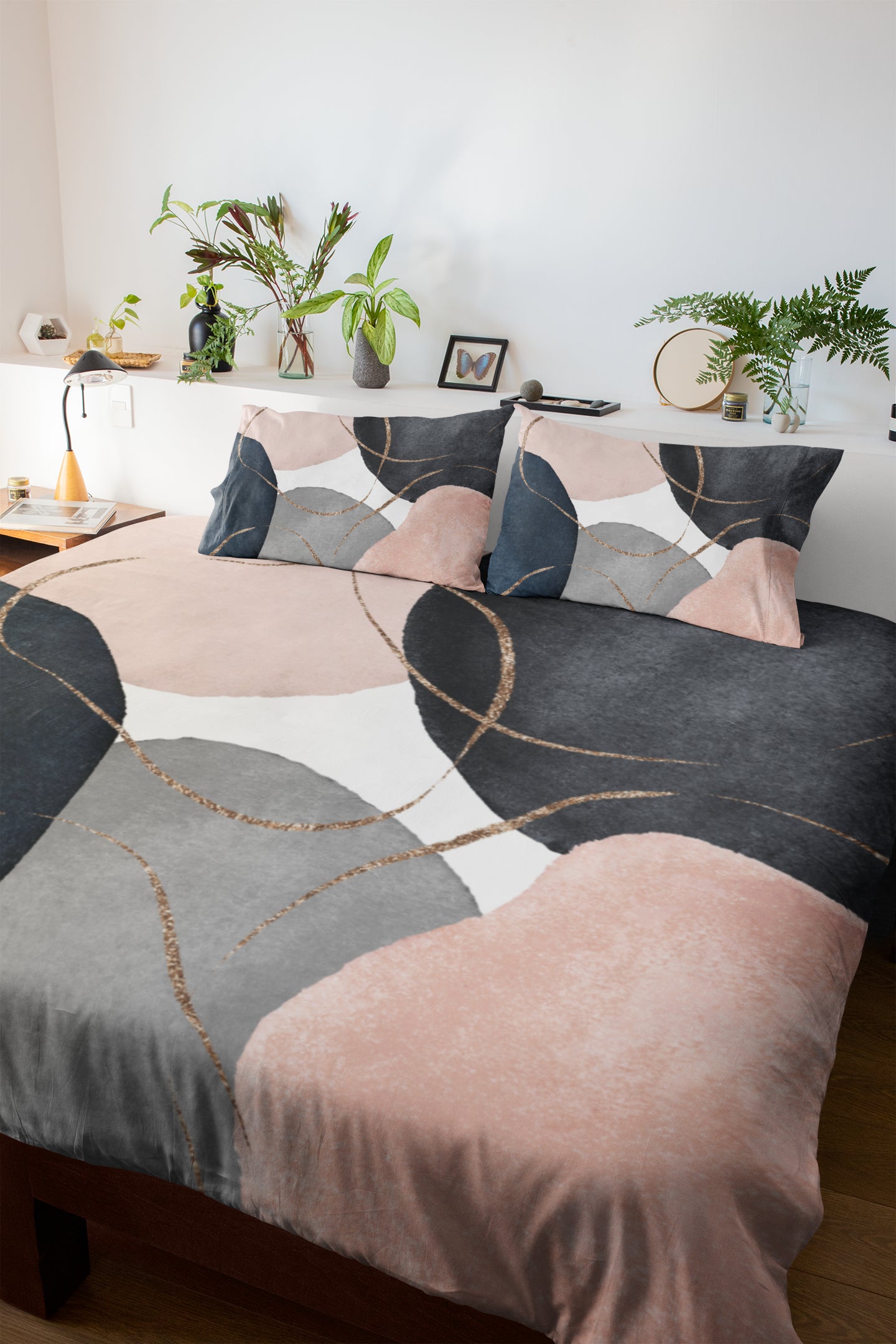 a bed with a pink and black comforter and pillows