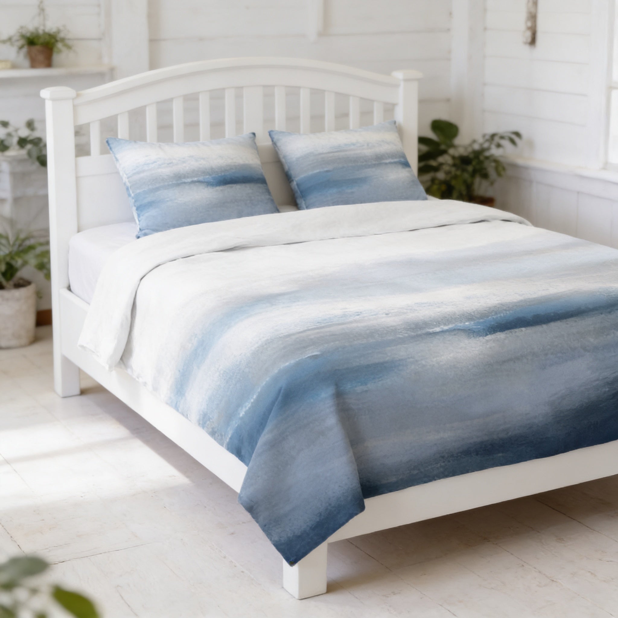 a white wooden bed with a blue and white patterned comforter and pillows, set against a white wall with a window.