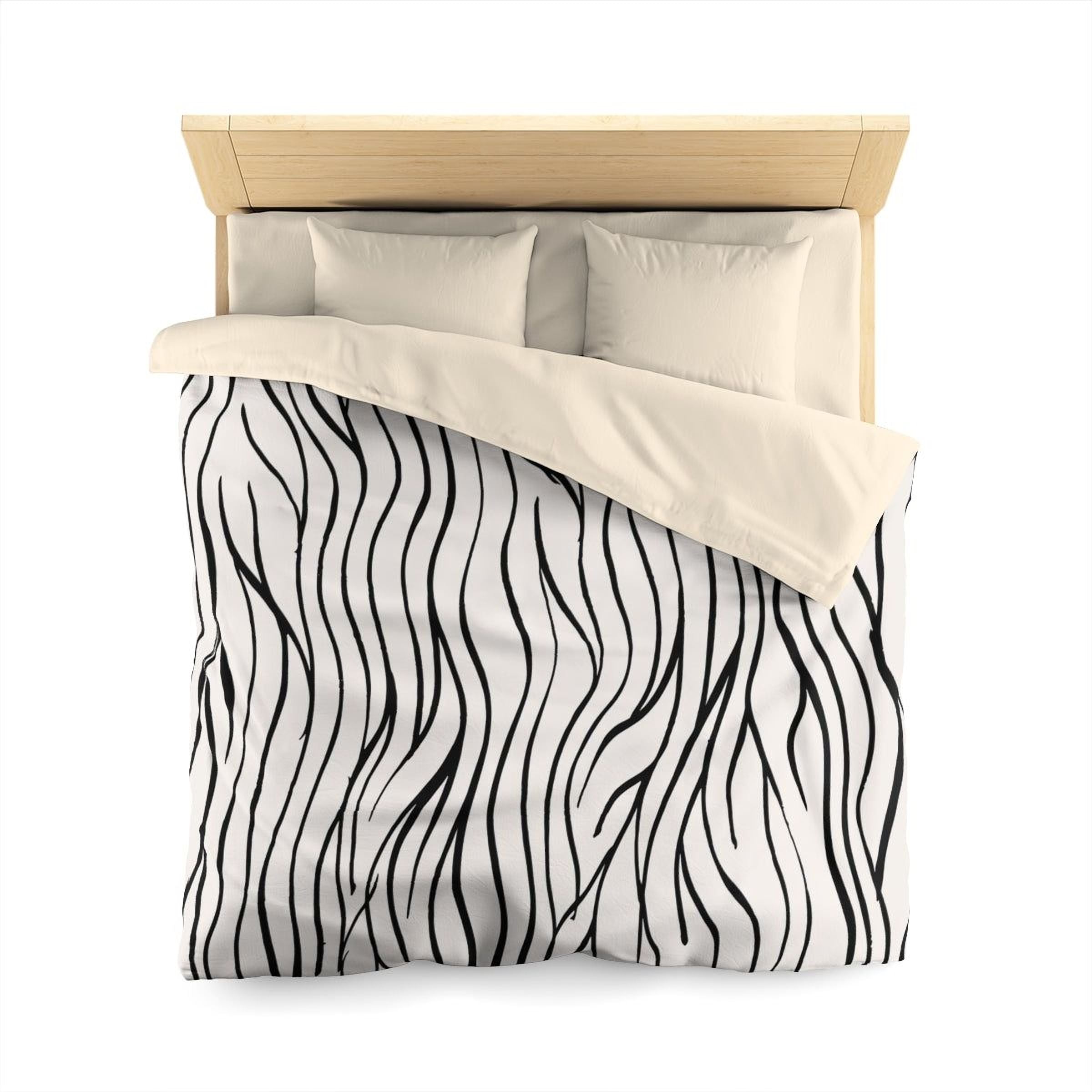 a neatly made bed with a black and white zigzag patterned comforter and two pillows.