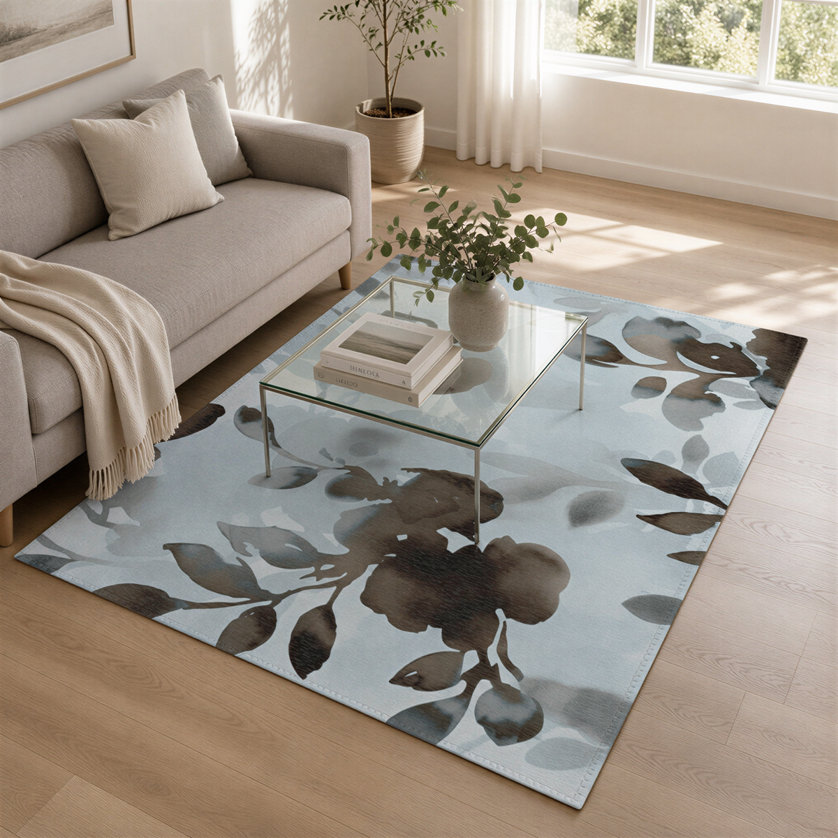 a cozy living room with a gray sofa, a glass coffee table with a vase of greenery, and a blue floral rug on the floor.
