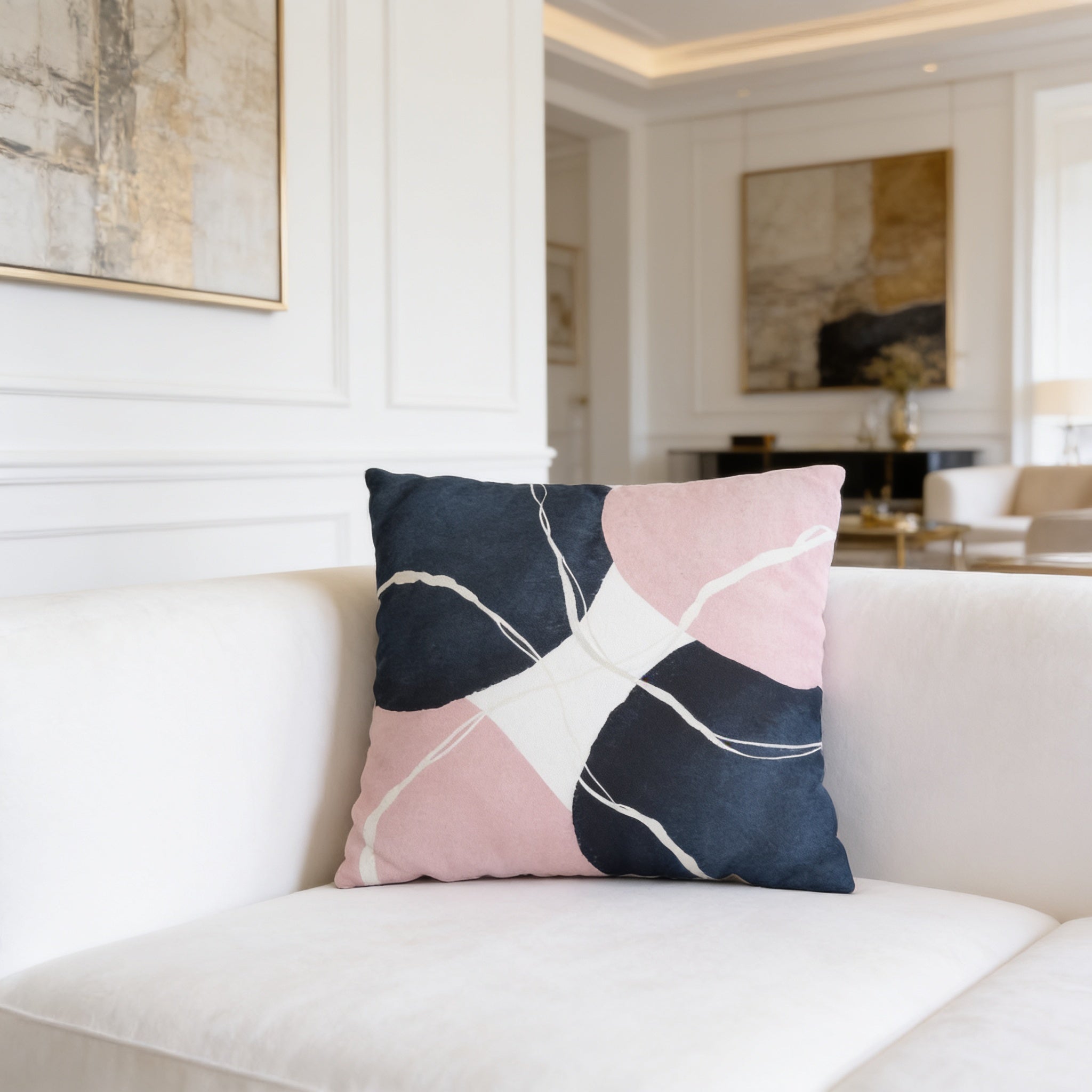 a white couch with a decorative pillow on it, which has a colorful abstract design in shades of pink, blue, and white.