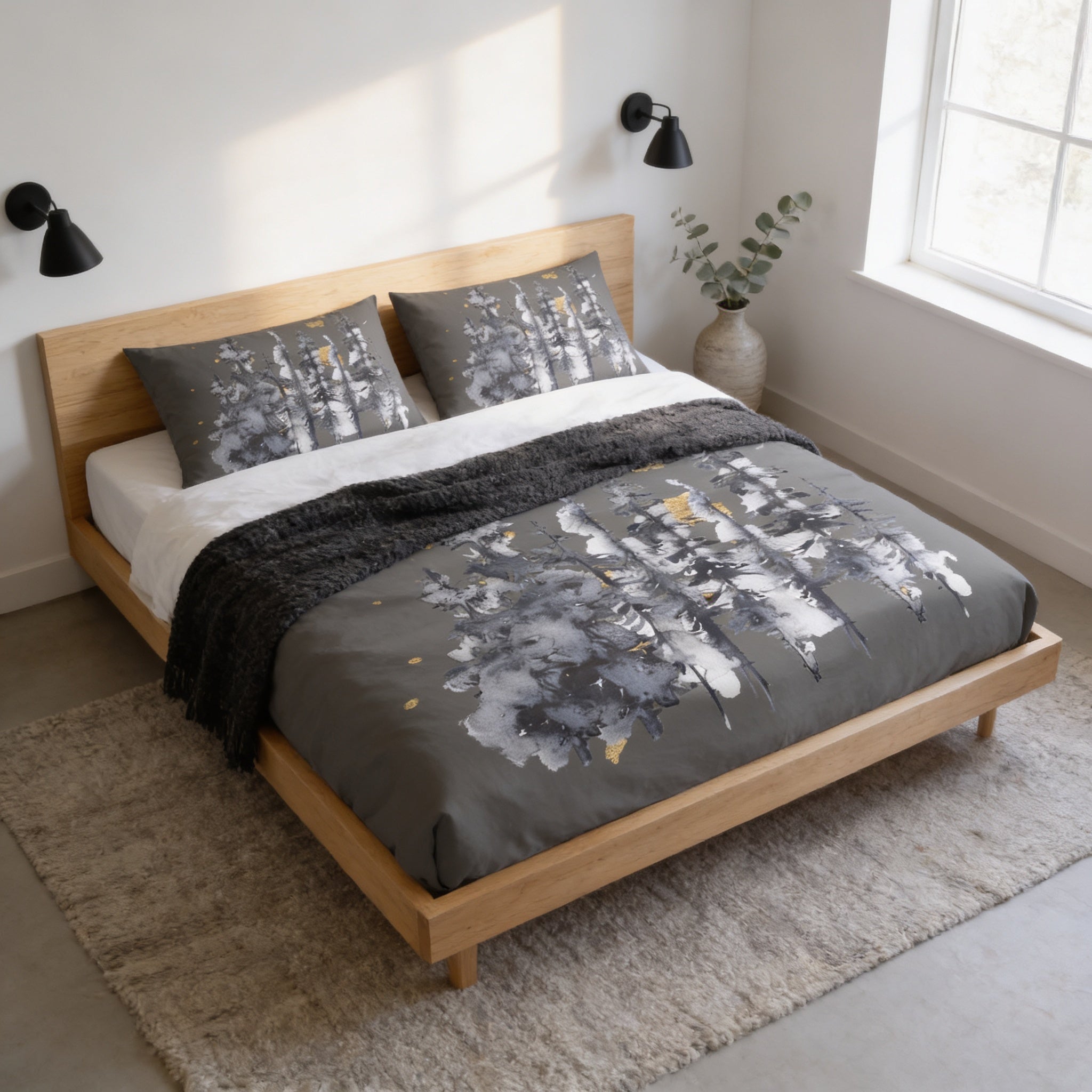 a modern bedroom with a wooden bed frame, a gray and white patterned comforter, and a black throw blanket. The bed is positioned against a white wall, with a window providing natural light. There is a small plant on the windowsill, adding a touch of greenery to the room.
